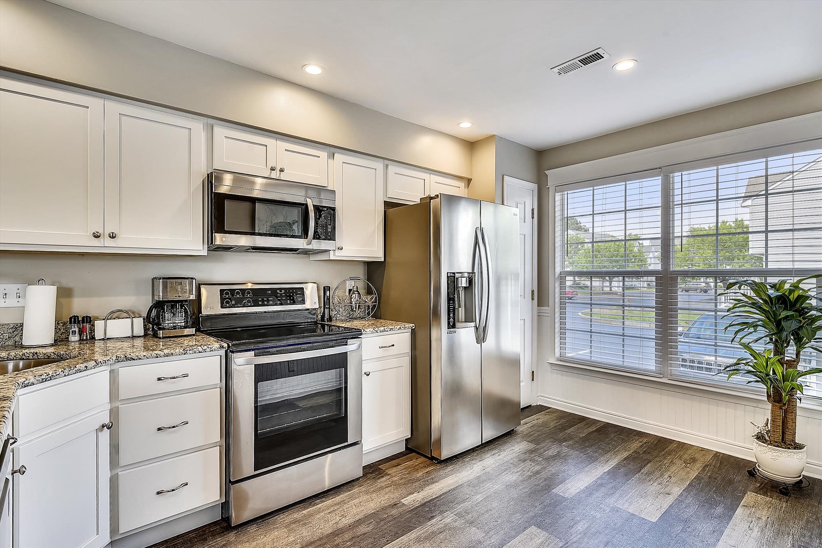 Step into your fully equipped kitchen with modern appliances, granite counters, and bright natural light streaming through large windows—perfect for preparing meals and starting your day.