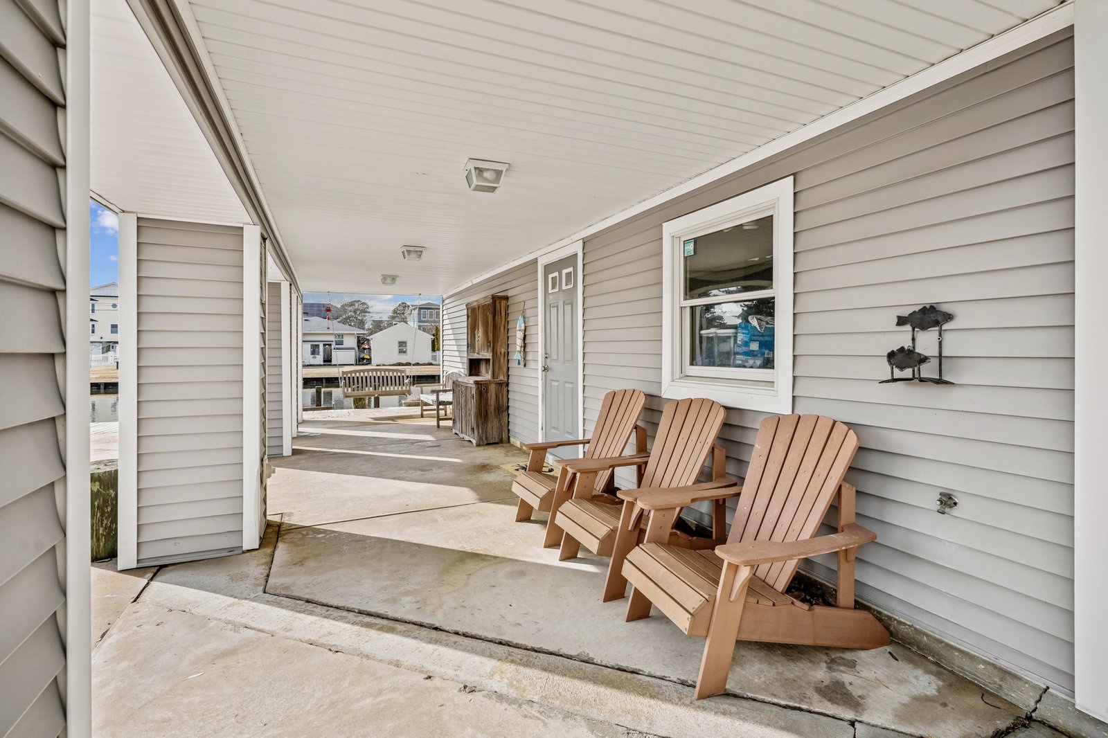 Unwind on your private covered porch with three Adirondack chairs, perfect for morning coffee or evening relaxation with neighborhood views.