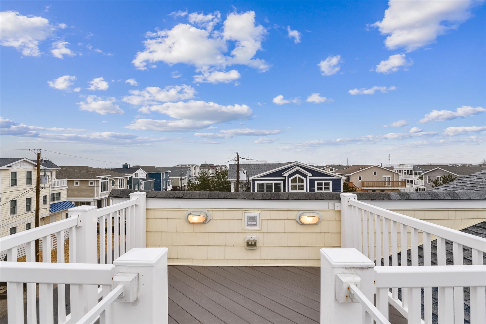 Private rooftop deck offering coastal neighborhood views and open sky—a distinctive feature of the property's exterior setting.