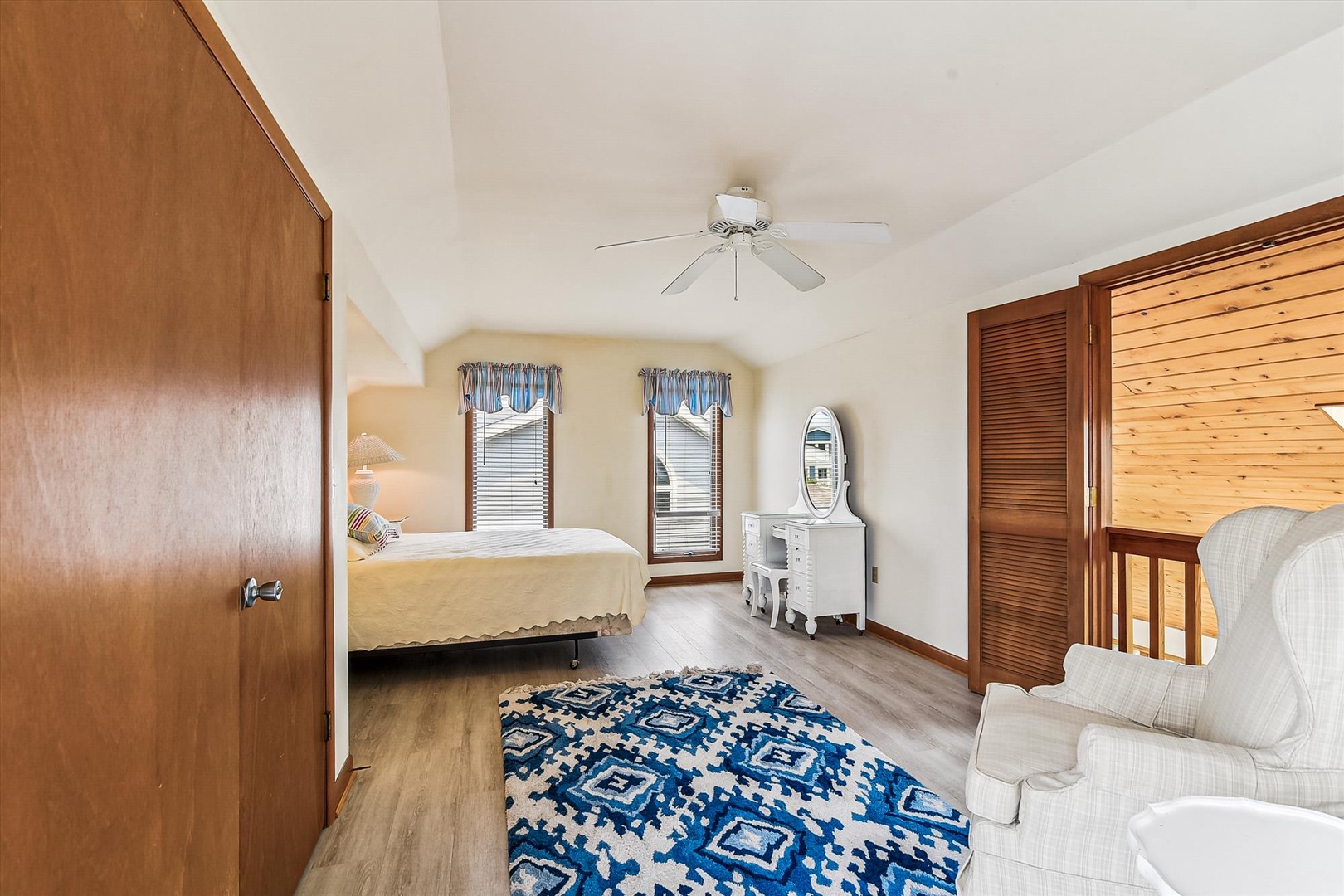 Unwind in your serene bedroom with vaulted ceilings, a comfy bed, and charming coastal touches. The ceiling fan keeps you cool while natural light streams through cheerful windows.