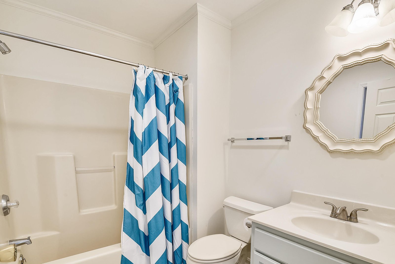 Freshen up in your bright, spotless bathroom with modern fixtures and a cheerful chevron shower curtain that adds a splash of coastal charm.