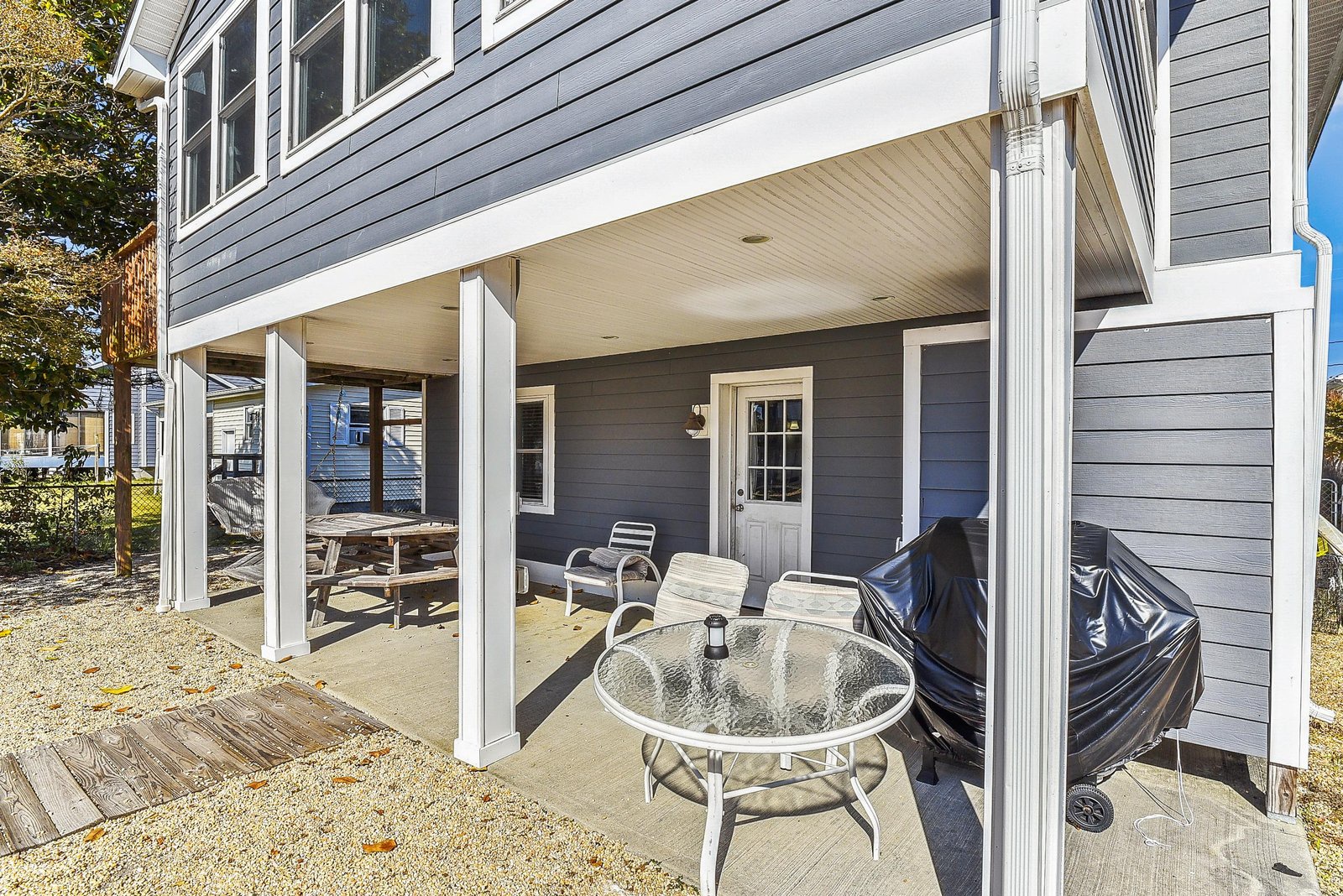 Step into your private covered patio, where a glass-top table and lounge seating await—ideal for morning coffee or evening gatherings beneath the shade.