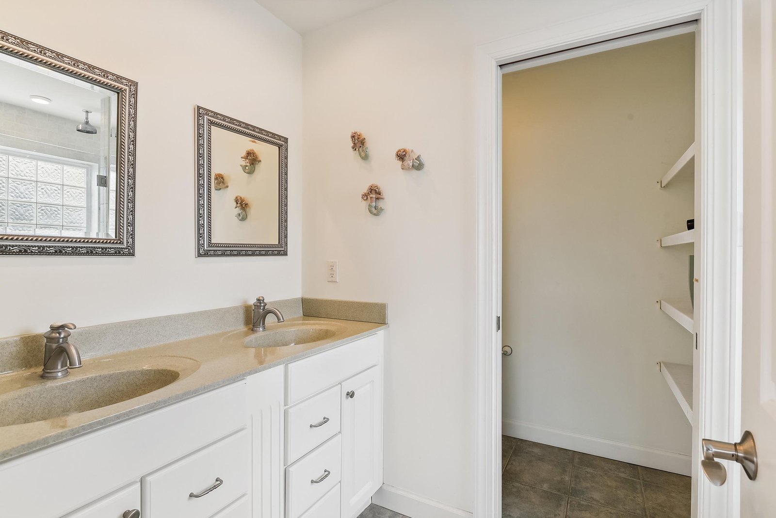 Freshen up at your double-sink vanity with modern fixtures and bright lighting, while ample storage keeps your essentials organized and close at hand.