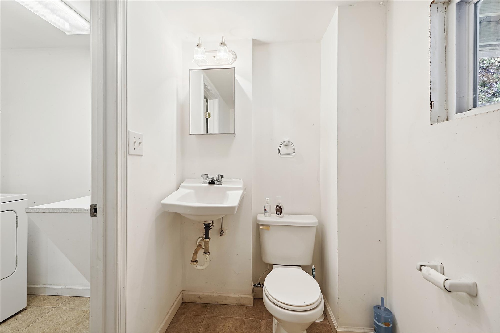 Your private bathroom features fresh white fixtures, a wall-mounted sink, and bright lighting—clean, functional, and ready for your stay.