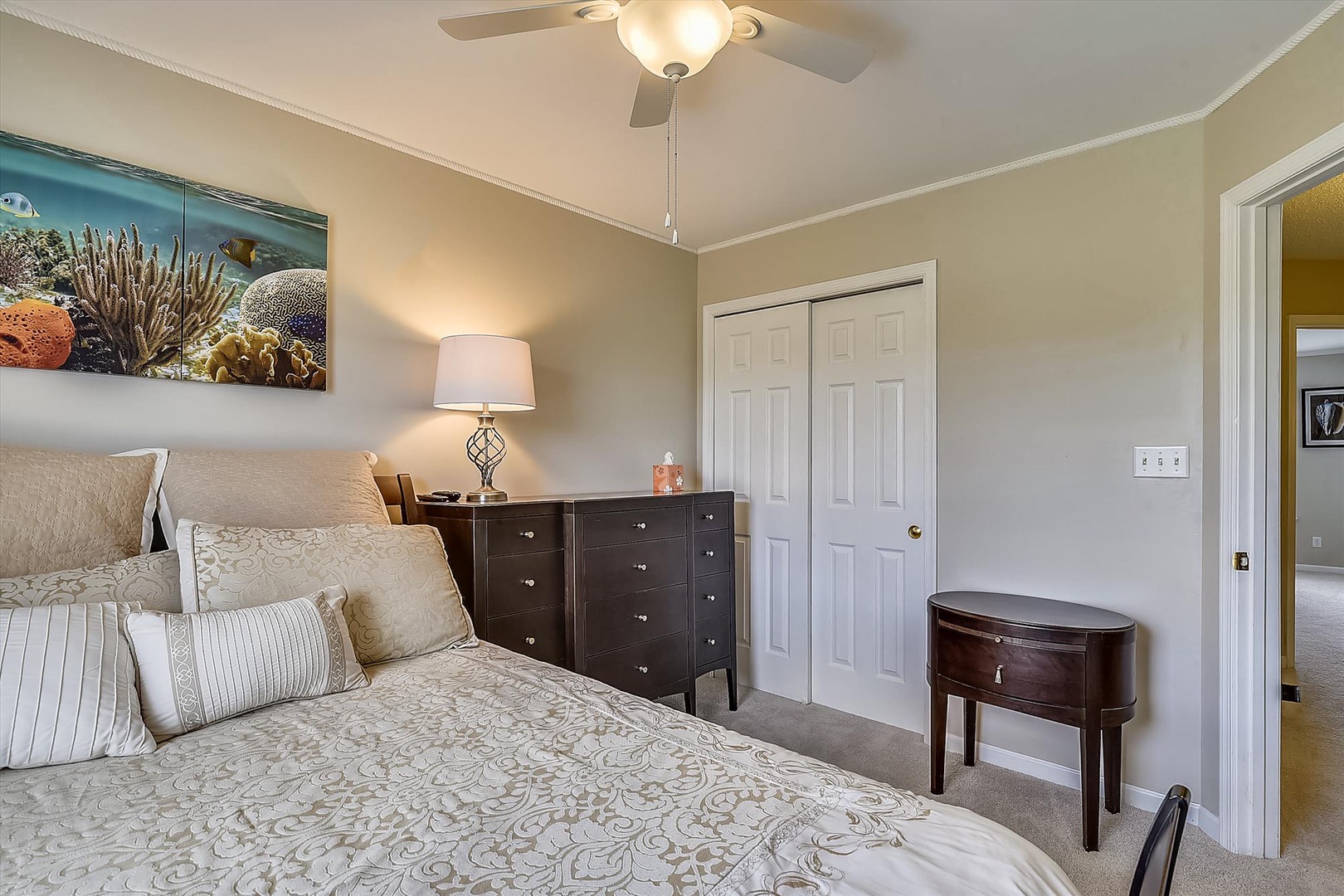 Unwind in your serene bedroom with elegant furnishings, coastal art, and soft lighting creating a peaceful retreat for restful nights.