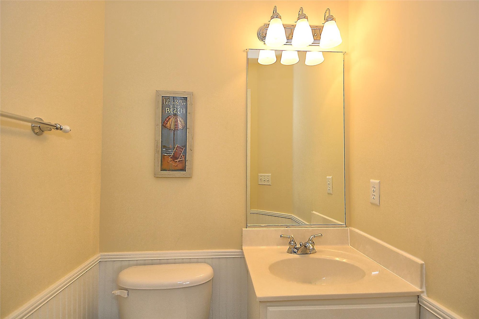 A bright, spotless bathroom with coastal décor awaits, ready for you to freshen up after a day at the beach.