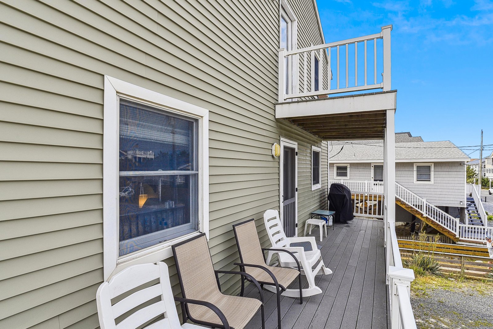 Your private deck awaits with comfortable seating, a gas grill, and a peaceful neighborhood view—perfect for morning coffee or evening barbecues under the open sky.