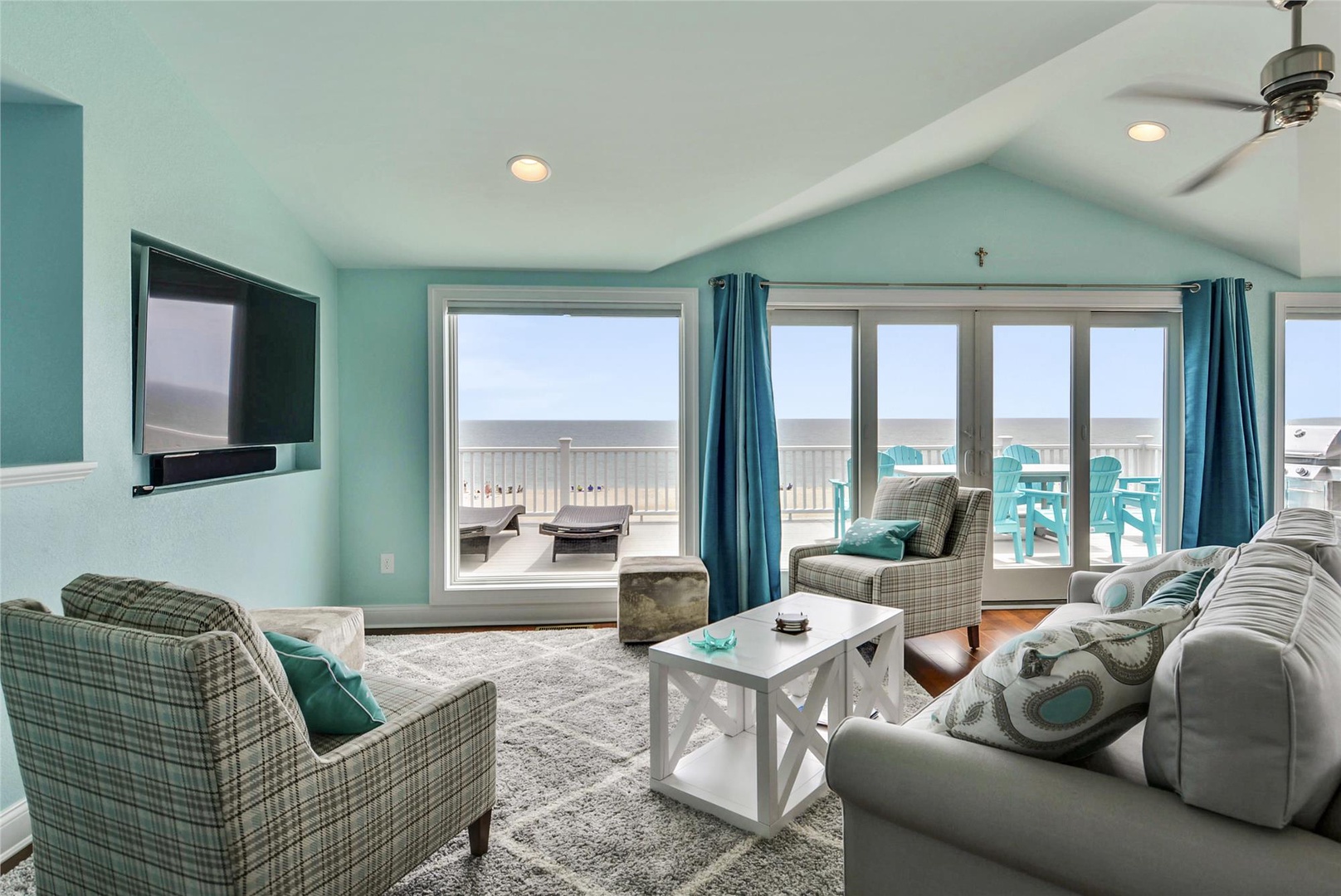 Unwind in your airy living room with vaulted ceilings, beach-inspired decor, and glass doors opening to the balcony where endless ocean views await you.
