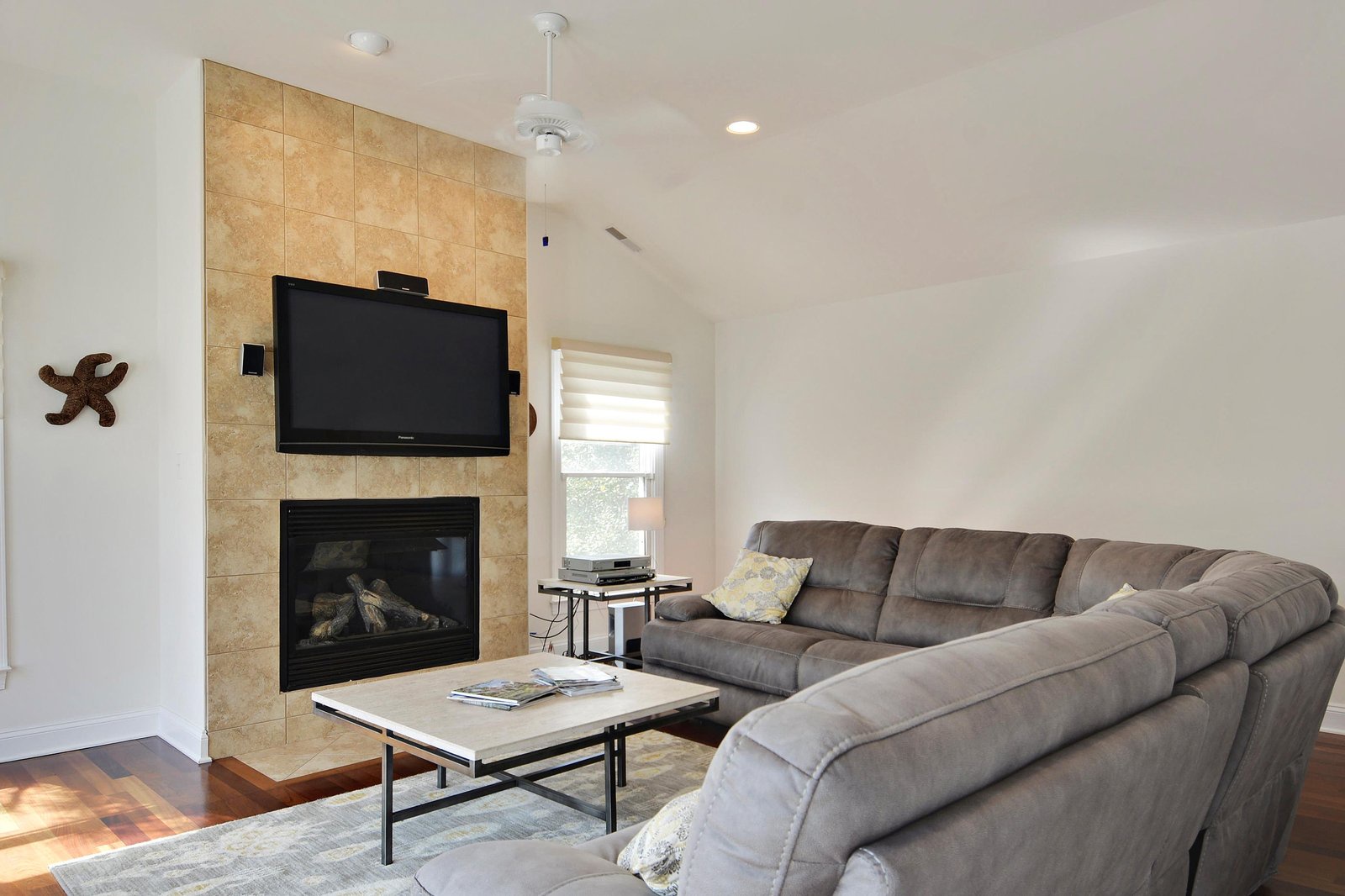 Sink into the plush sectional and enjoy cozy evenings by the warm fireplace in your bright, airy living space.