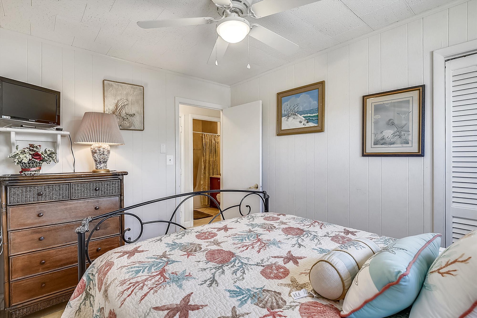 Unwind in your cozy coastal bedroom, where nautical-themed artwork, soft linens with seashell patterns, and gentle ceiling fan breezes create your perfect seaside retreat.