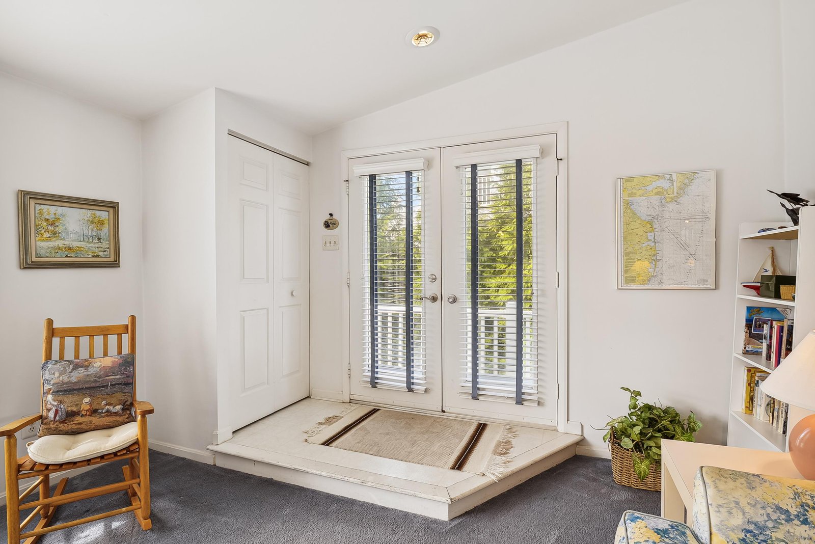 Step into your welcoming entryway where natural light floods through glass doors, and charming touches like artwork and a cozy reading nook create an inviting sense of arrival.