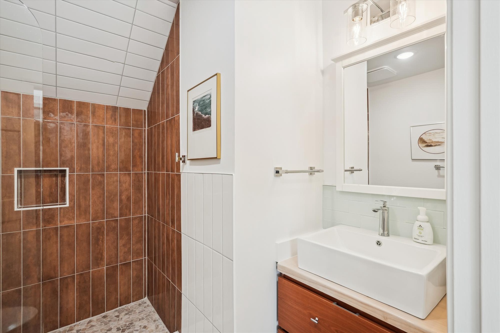 Step into your private spa-like bathroom with warm terracotta tiles, a sleek walk-in shower, and modern vanity—designed to help you unwind in style.