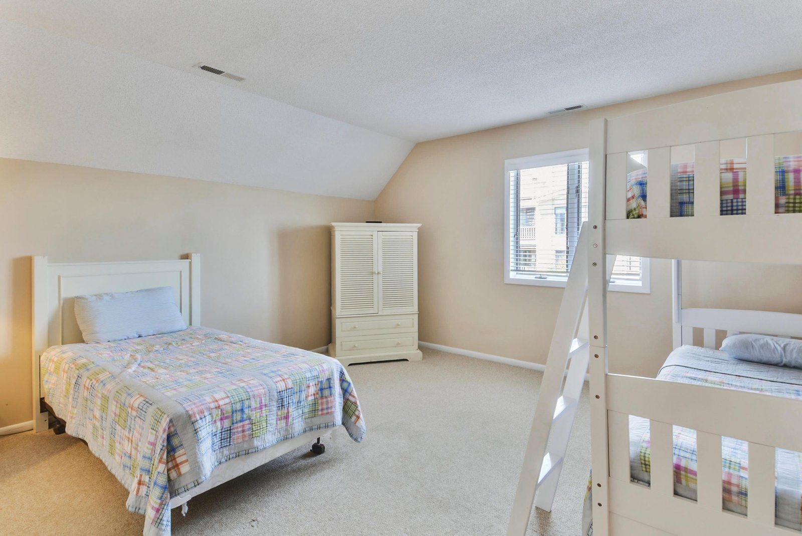 Your spacious bedroom features soft natural light, cozy beds with cheerful quilts, and plenty of room for the whole family to unwind after a day of exploring.