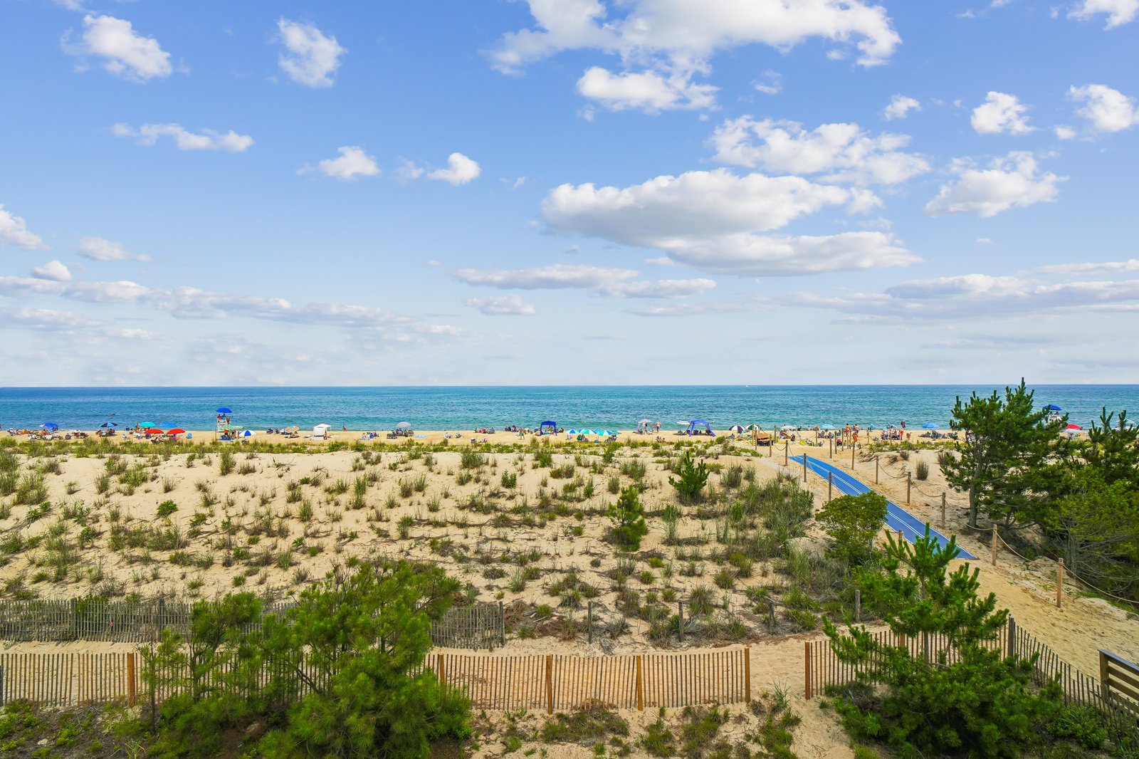 Sandy shores meet sparkling turquoise waters under a bright open sky—this is the beautiful beach just moments from your vacation retreat.
