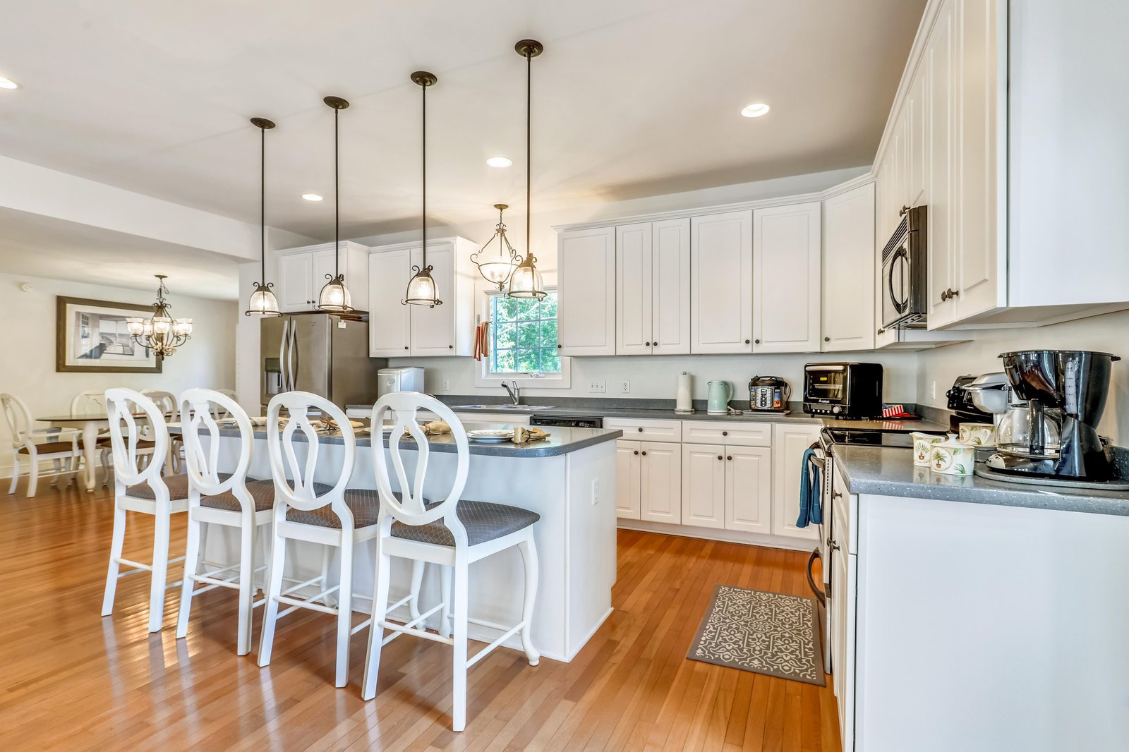 A bright, fully equipped kitchen with a spacious island invites you to gather and create. Elegant pendant lighting and modern appliances make meal prep effortless and enjoyable.