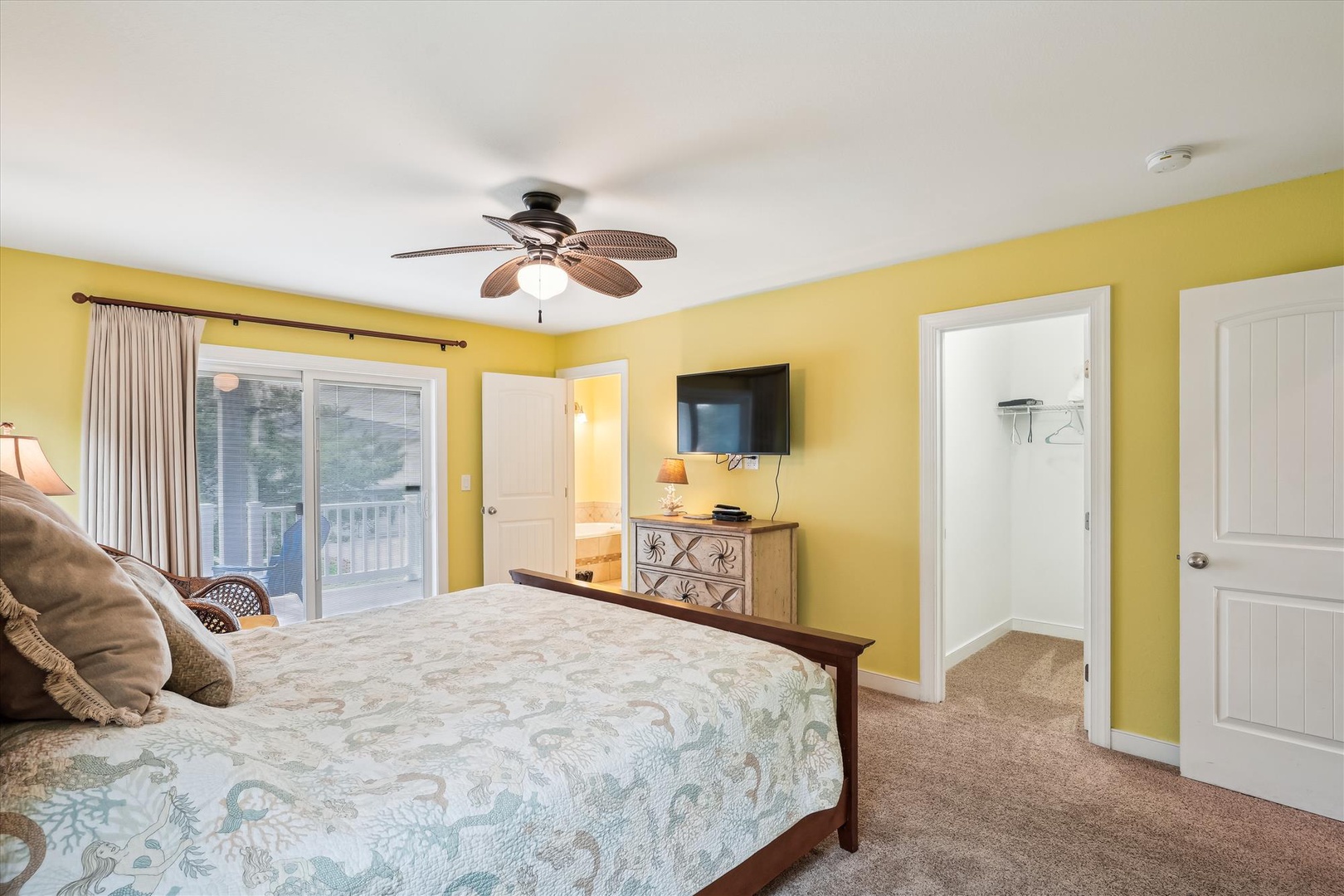You'll love waking up in this cheerful bedroom with its bright coastal vibes, balcony access, and soothing tropical decor that invites relaxation after every adventure.