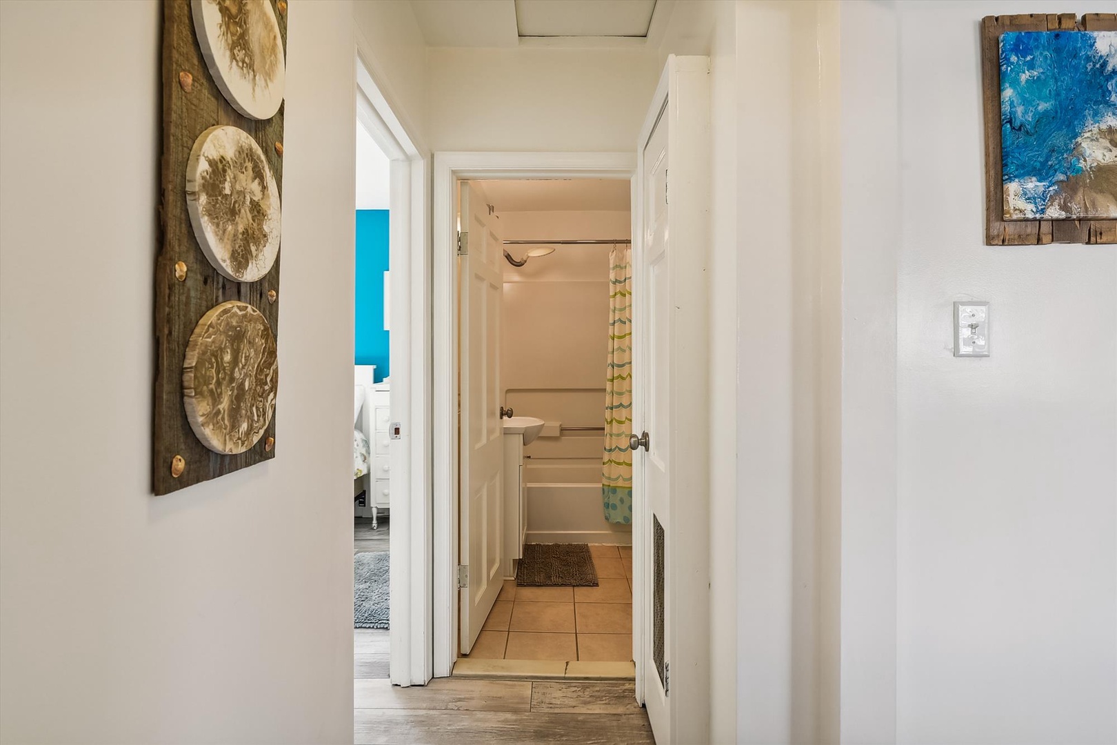 Your personal hallway connects the bedroom to your private bath, with beach-inspired artwork welcoming you home after a day of seaside adventures.