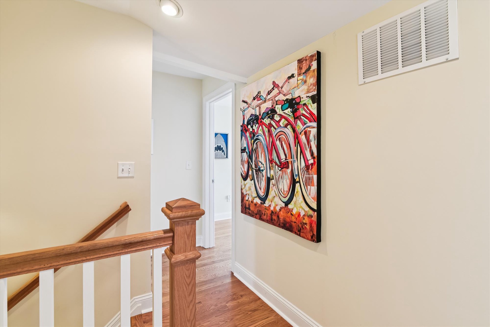 A bright hallway adorned with vibrant bicycle artwork welcomes you, combining warm tones and playful color that make every arrival feel uplifting and refreshing.