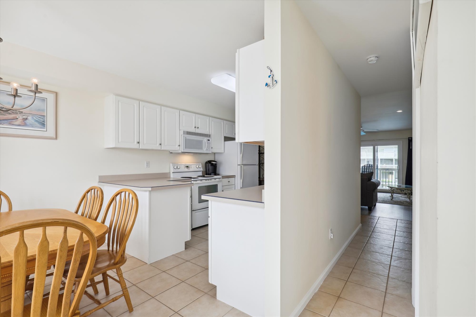 A bright, open-concept kitchen with crisp white cabinetry, modern appliances, and a cozy dining area where you can share morning coffee or plan your day's adventures together.
