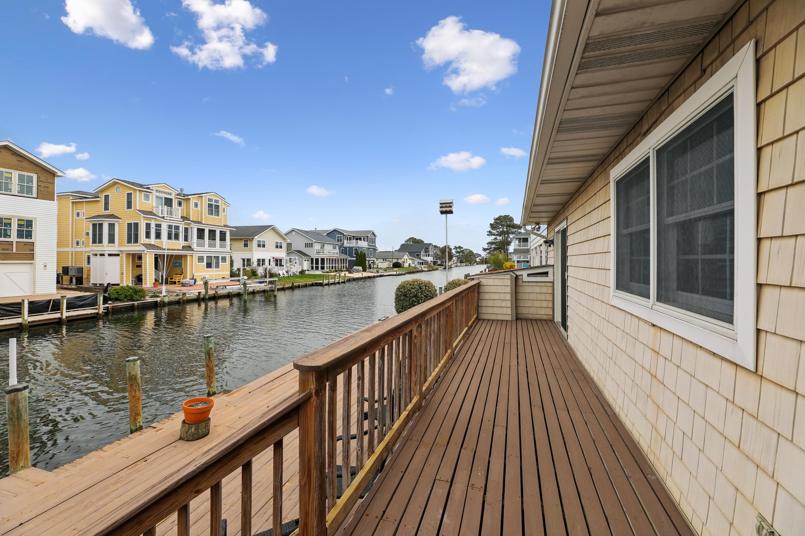 Step onto your private waterfront deck and take in the tranquil canal views stretching toward colorful neighboring homes. The spacious wooden deck invites you to enjoy morning coffee or evening sunsets over the peaceful water.