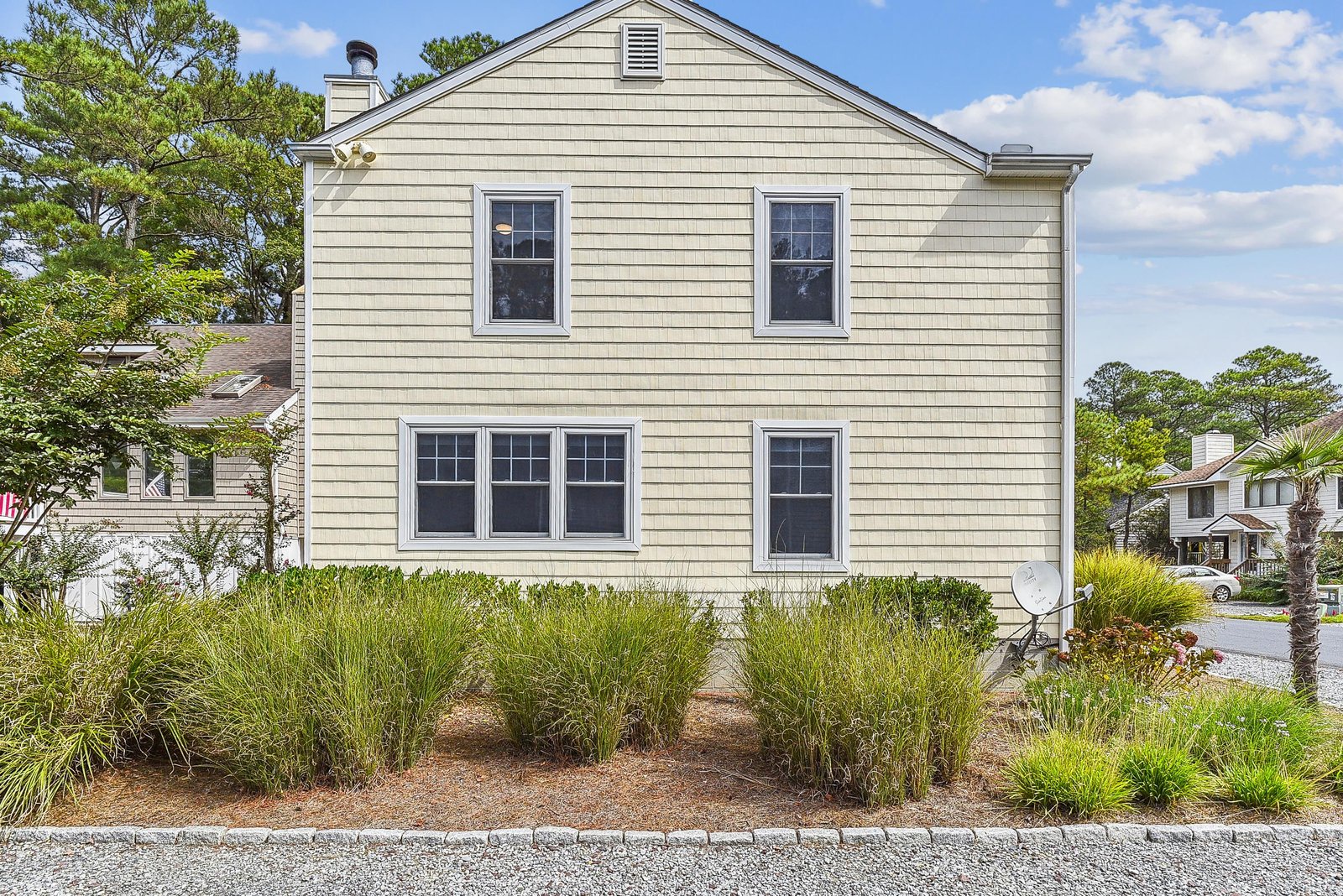 The property exterior features classic coastal architecture with landscaped grounds and convenient off-street parking—your relaxing getaway in a peaceful residential neighborhood.