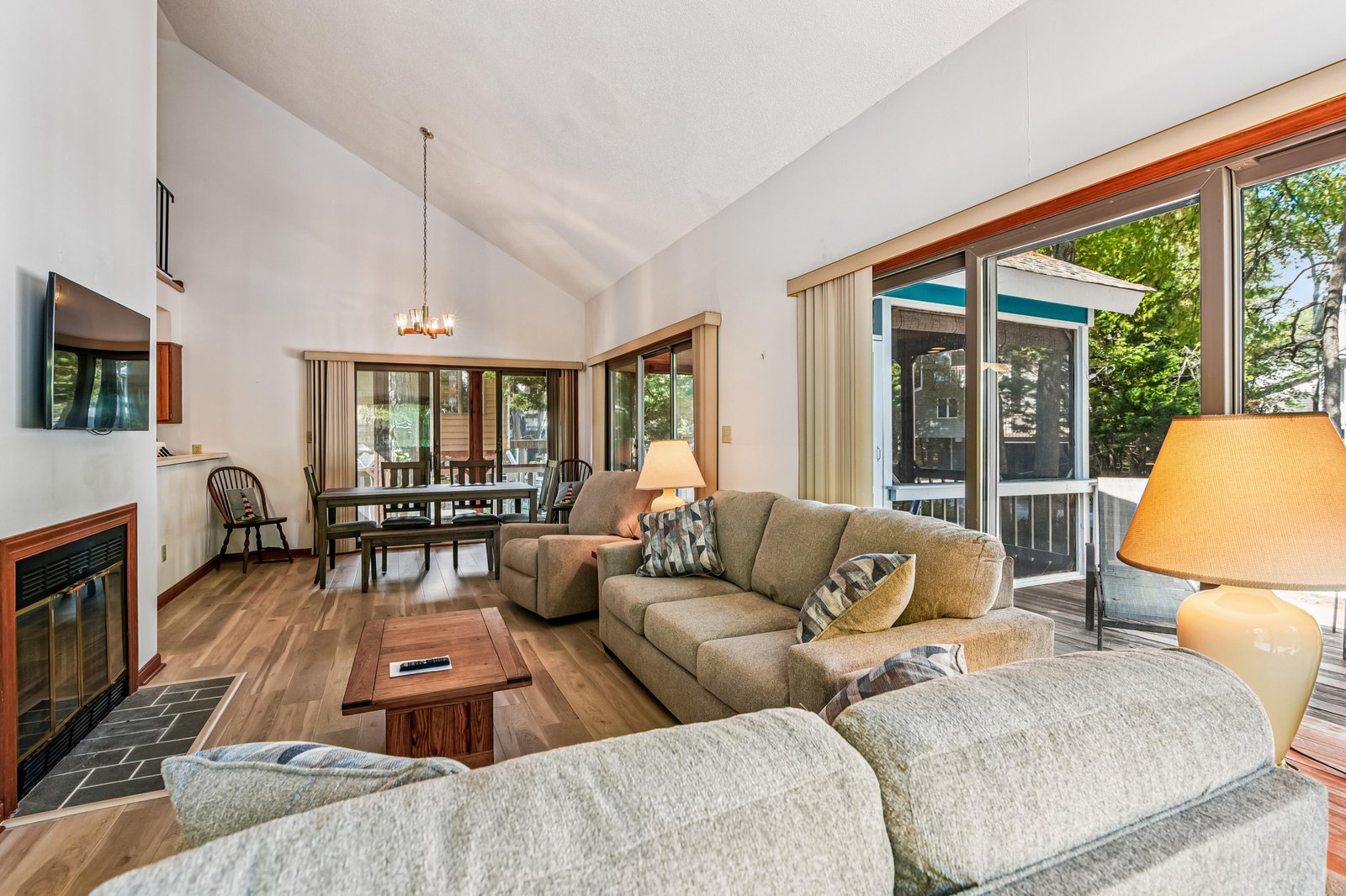 Relax in your spacious, naturally lit living room with vaulted ceilings and large windows that frame beautiful tree-lined views. The open layout connects to the dining area, perfect for gathering with family and friends.