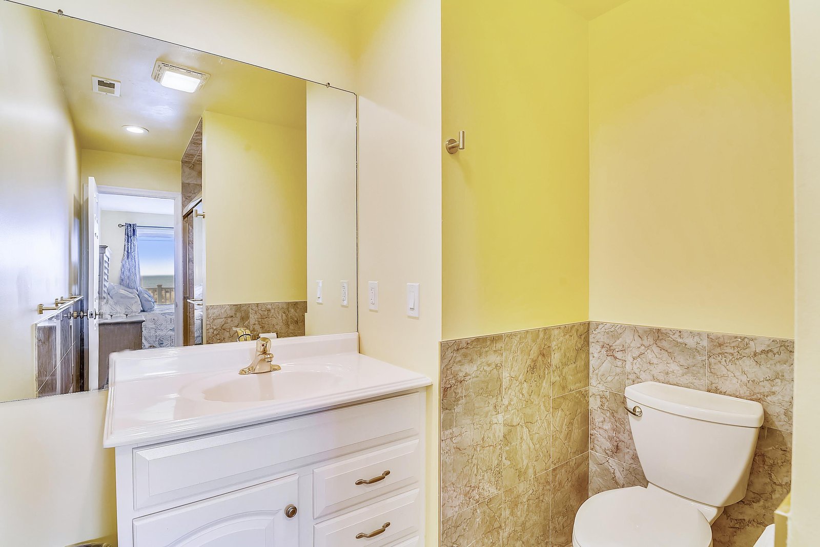 Bright and cheerful, your bathroom greets you with sunny yellow walls and warm stone accents. The crisp white vanity and modern fixtures create a fresh, welcoming space to start or end your day.
