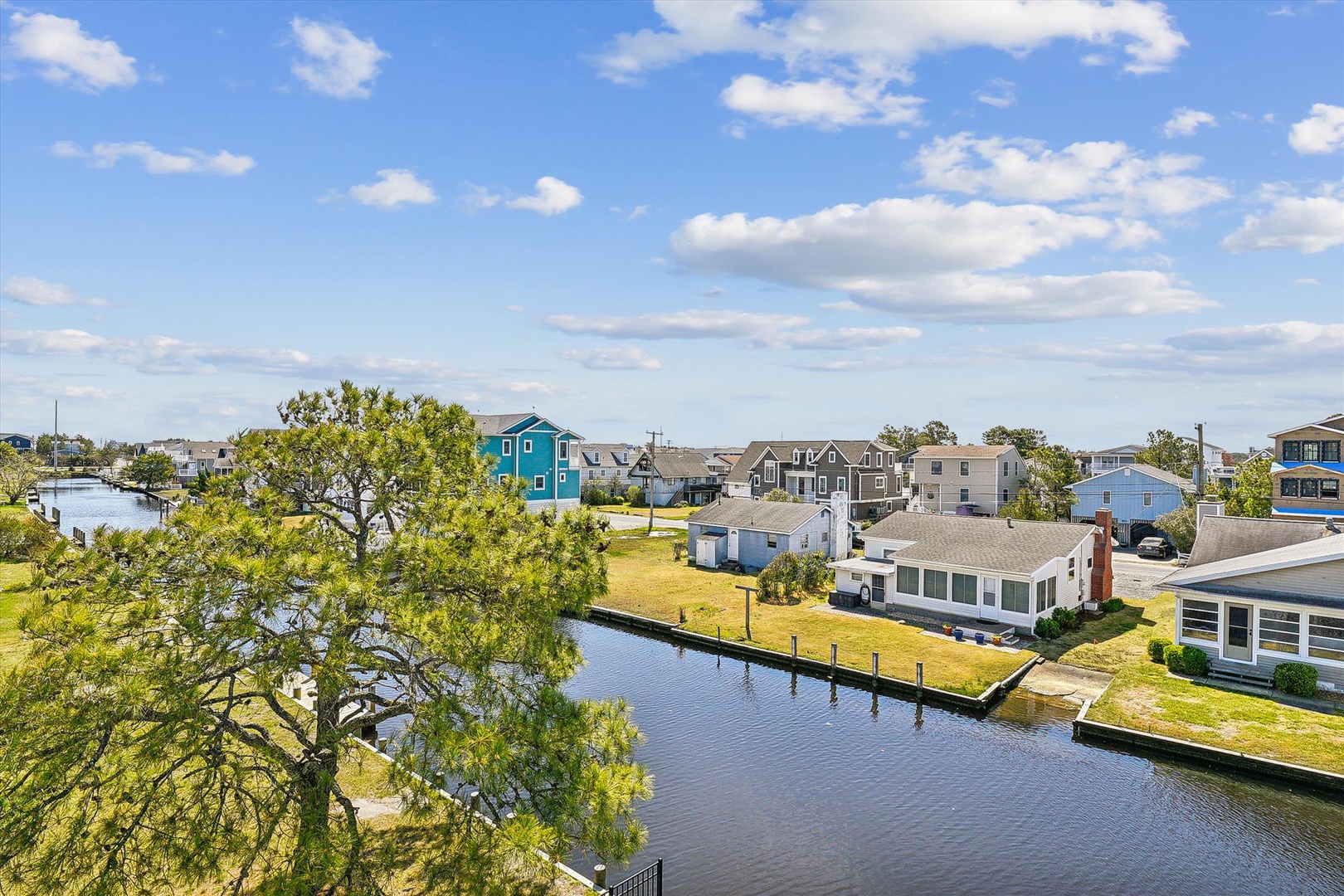 Aerial perspective of the waterfront community featuring the property nestled along a scenic canal with private docking, surrounded by coastal homes and accessible to nearby marinas.