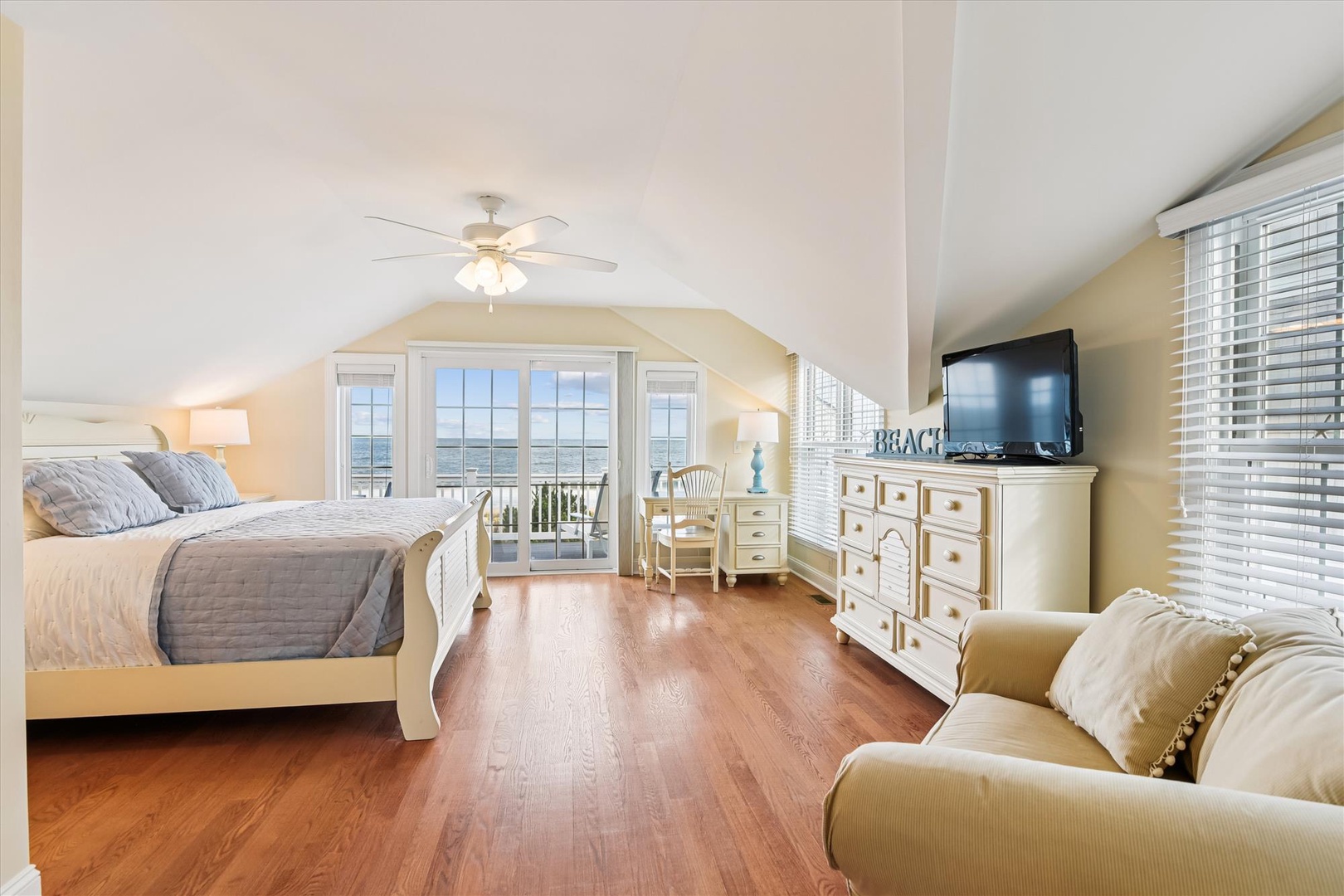 Your coastal bedroom features rich hardwood floors, a ceiling fan for comfort, and a flat-screen TV for entertainment. Step out to your private balcony and soak in stunning ocean views.
