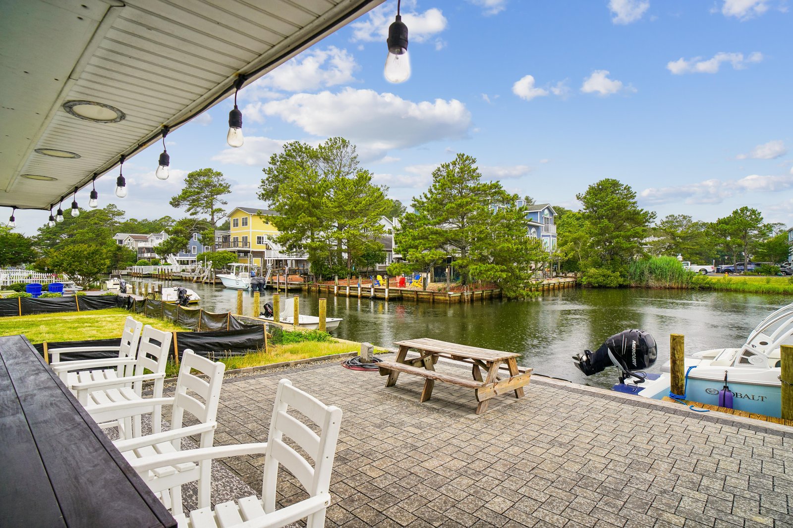 Waterfront patio offers a peaceful spot to unwind. Settle into cozy seating overlooking boats and tree-lined canals—a perfect retreat after exploring nearby attractions.