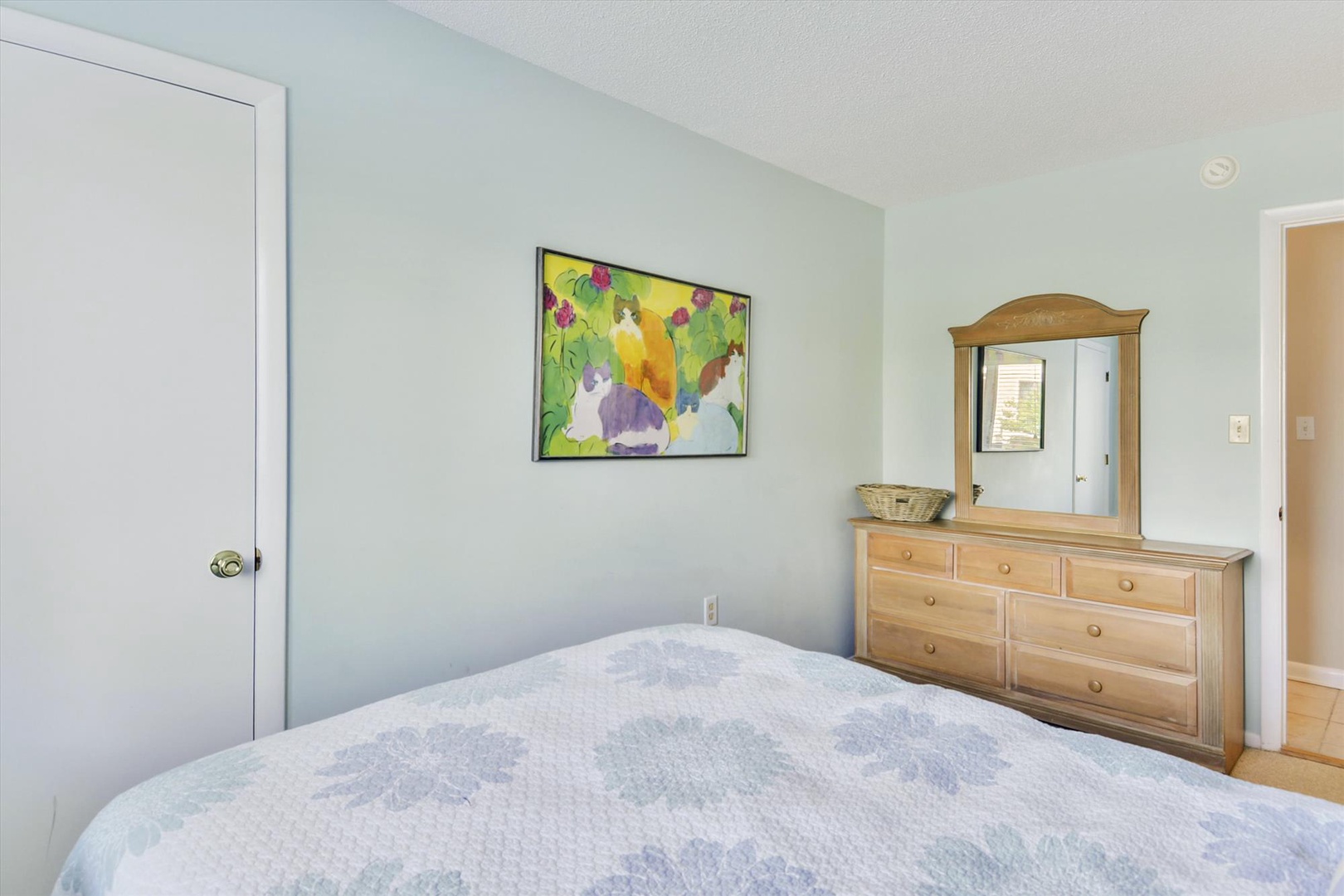 Rest easy in your serene bedroom, featuring soft linens, a cheerful art piece, and ample storage to keep your belongings organized throughout your stay.