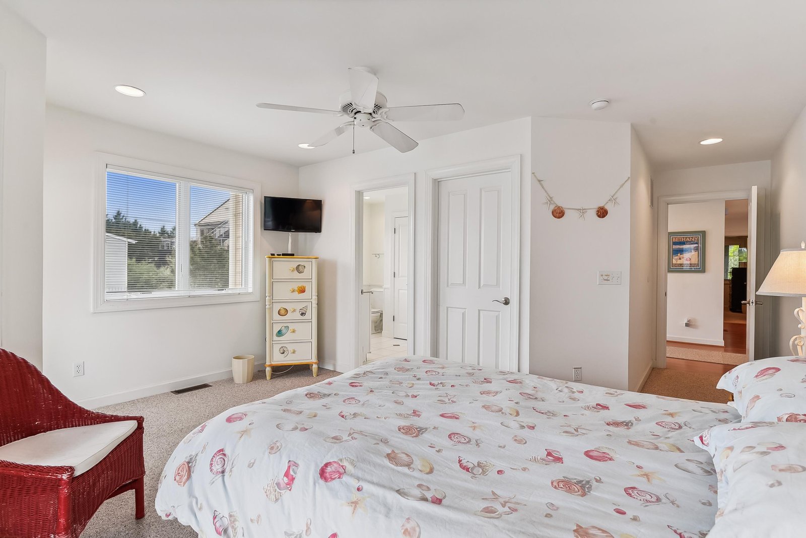 Your bright, airy bedroom awaits with soft coastal charm, gentle natural light, and a ceiling fan to keep you cool during warm summer nights.