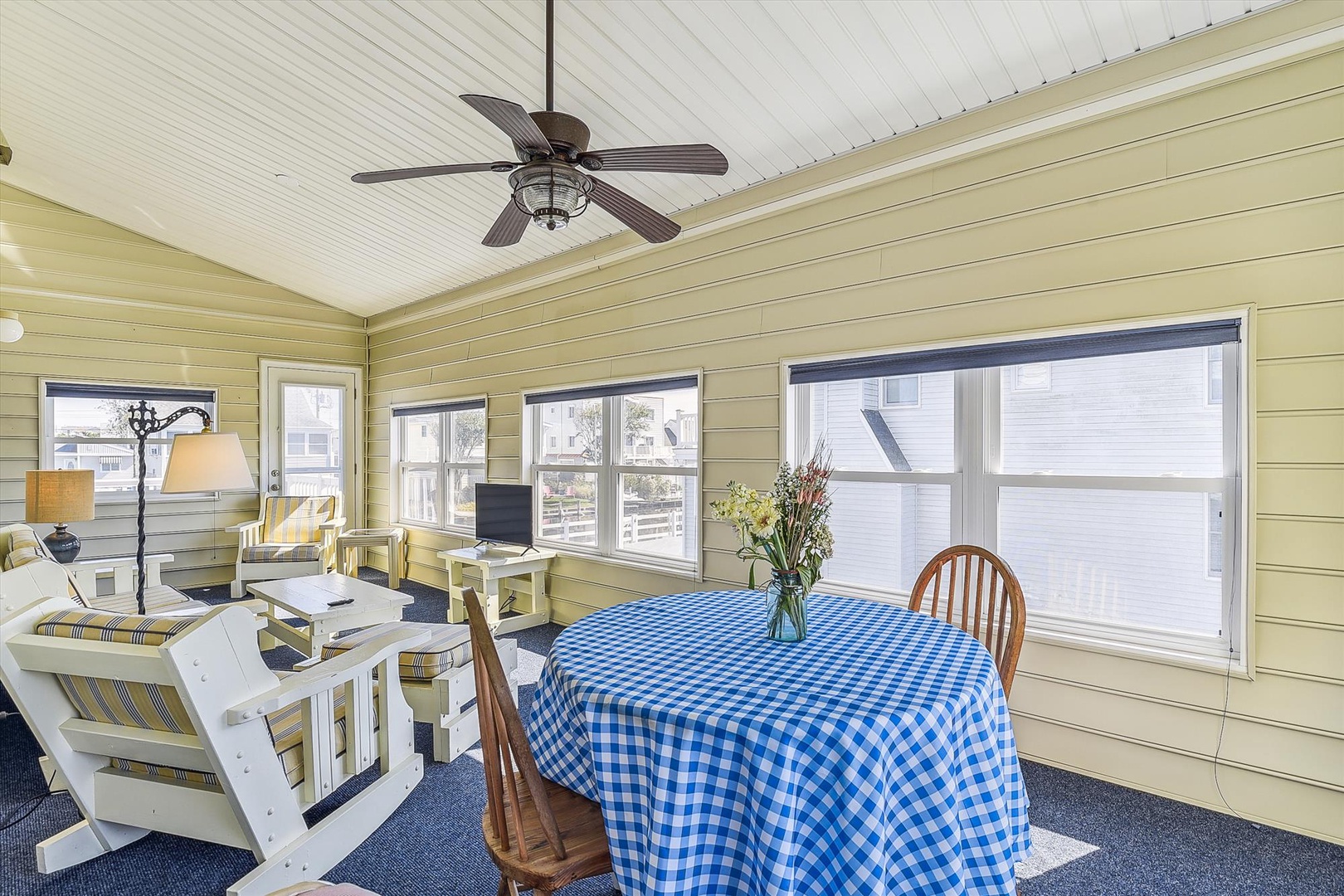 Relax in your bright sunroom with vaulted ceilings, ceiling fan, and cheerful coastal décor—perfect for sipping morning coffee or unwinding after a day at the beach.