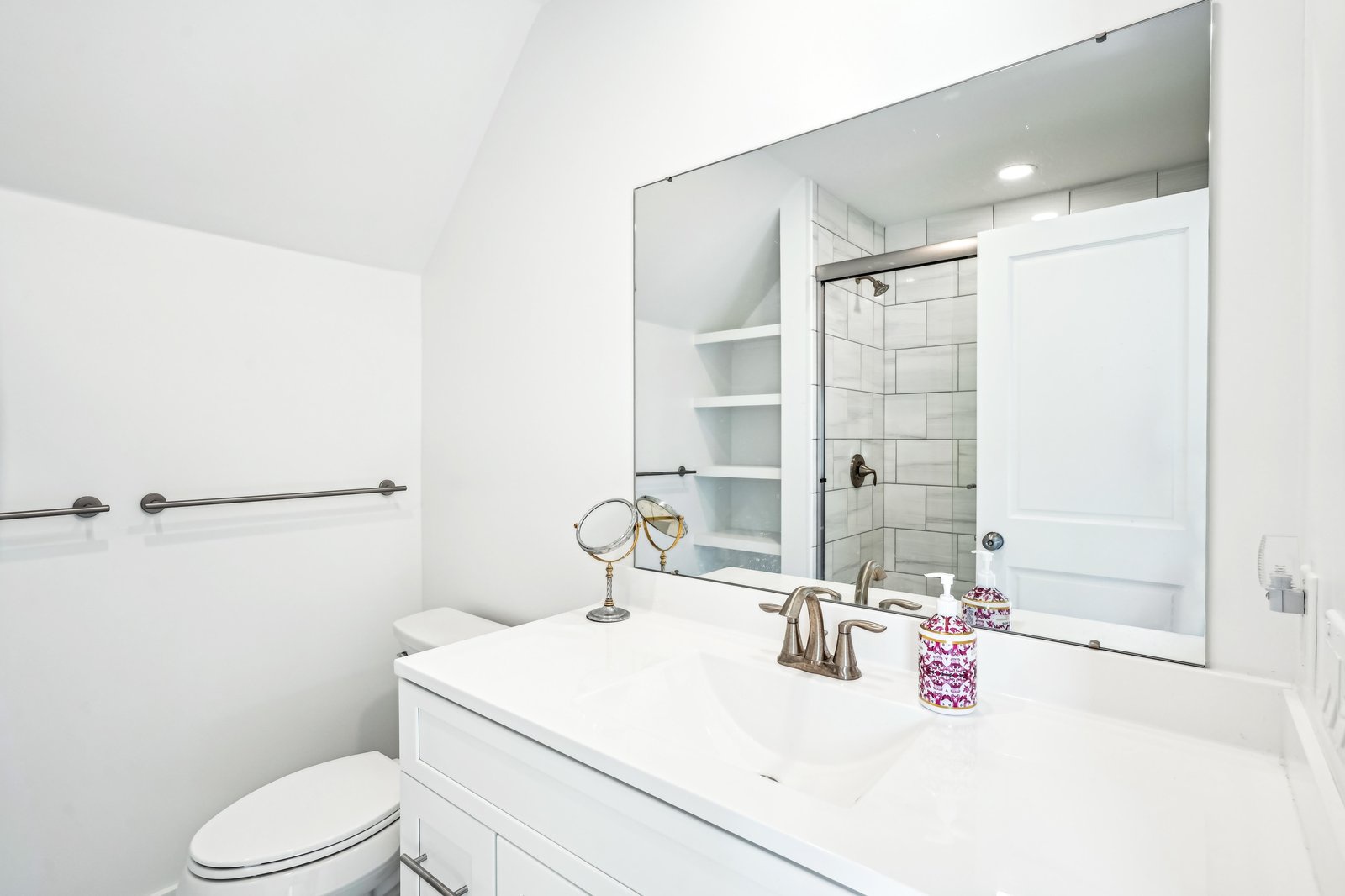 Step into your pristine, spa-like bathroom with gleaming white tile and a spacious walk-in shower. Fresh, bright, and beautifully appointed—every detail designed for your comfort and ease.