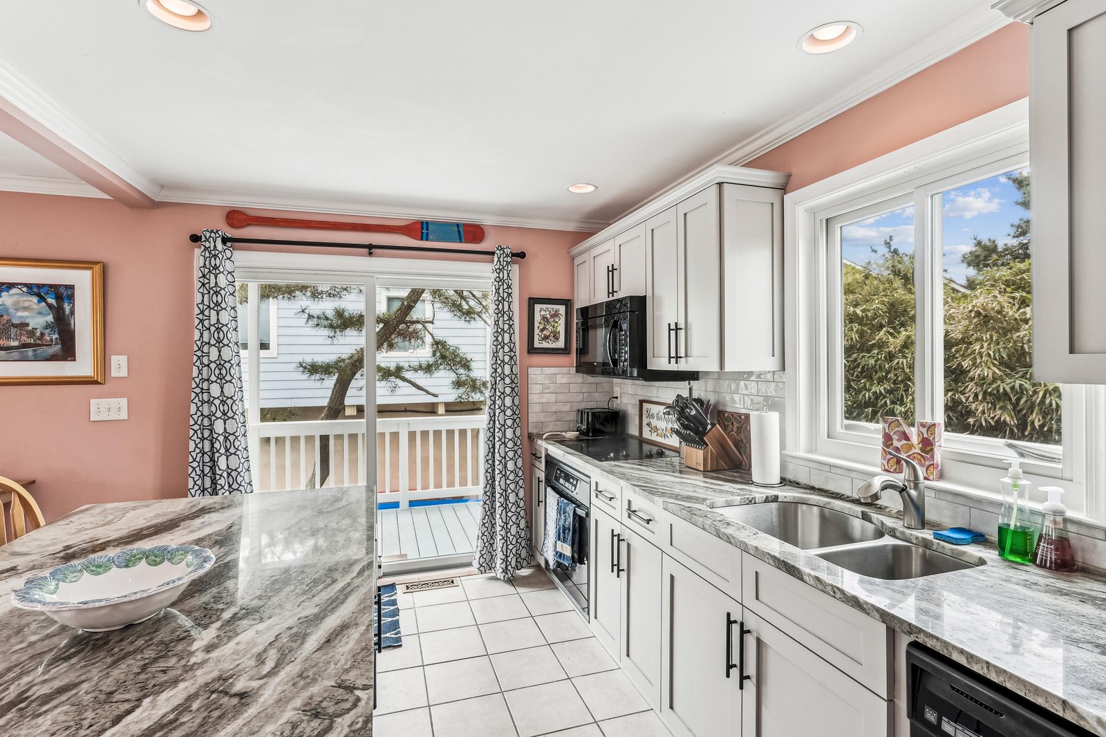 Cook your favorite meals in this bright, modern kitchen with gleaming granite countertops, stainless appliances, and plenty of natural light streaming through large windows overlooking the peaceful outdoors.