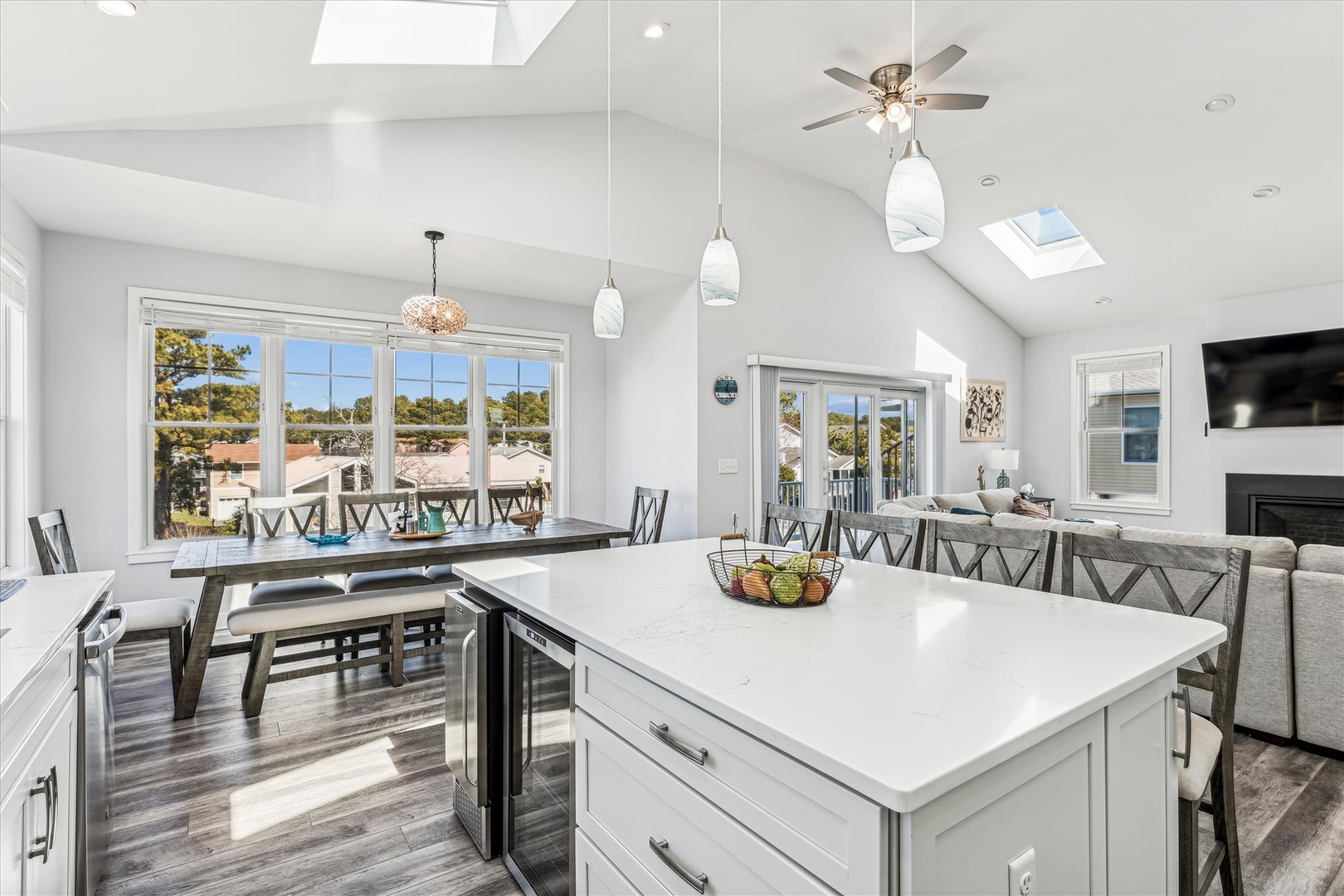 Your open-concept gathering space glows with natural light. Imagine cooking at the island while guests relax nearby, then sharing meals with stunning views through expansive windows and doors.