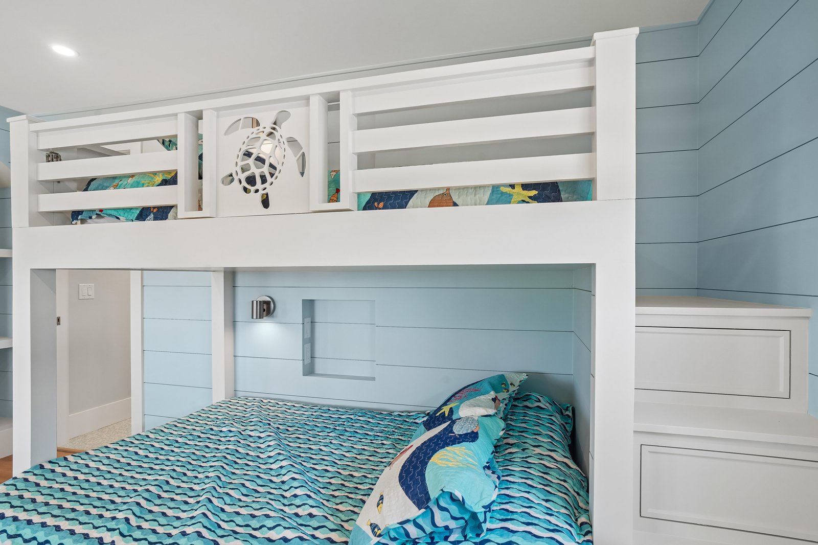 Your little ones will love climbing into this coastal-themed bunk bed, complete with sea turtle décor and ocean-inspired bedding—perfect for drifting off to dreams of beach adventures.