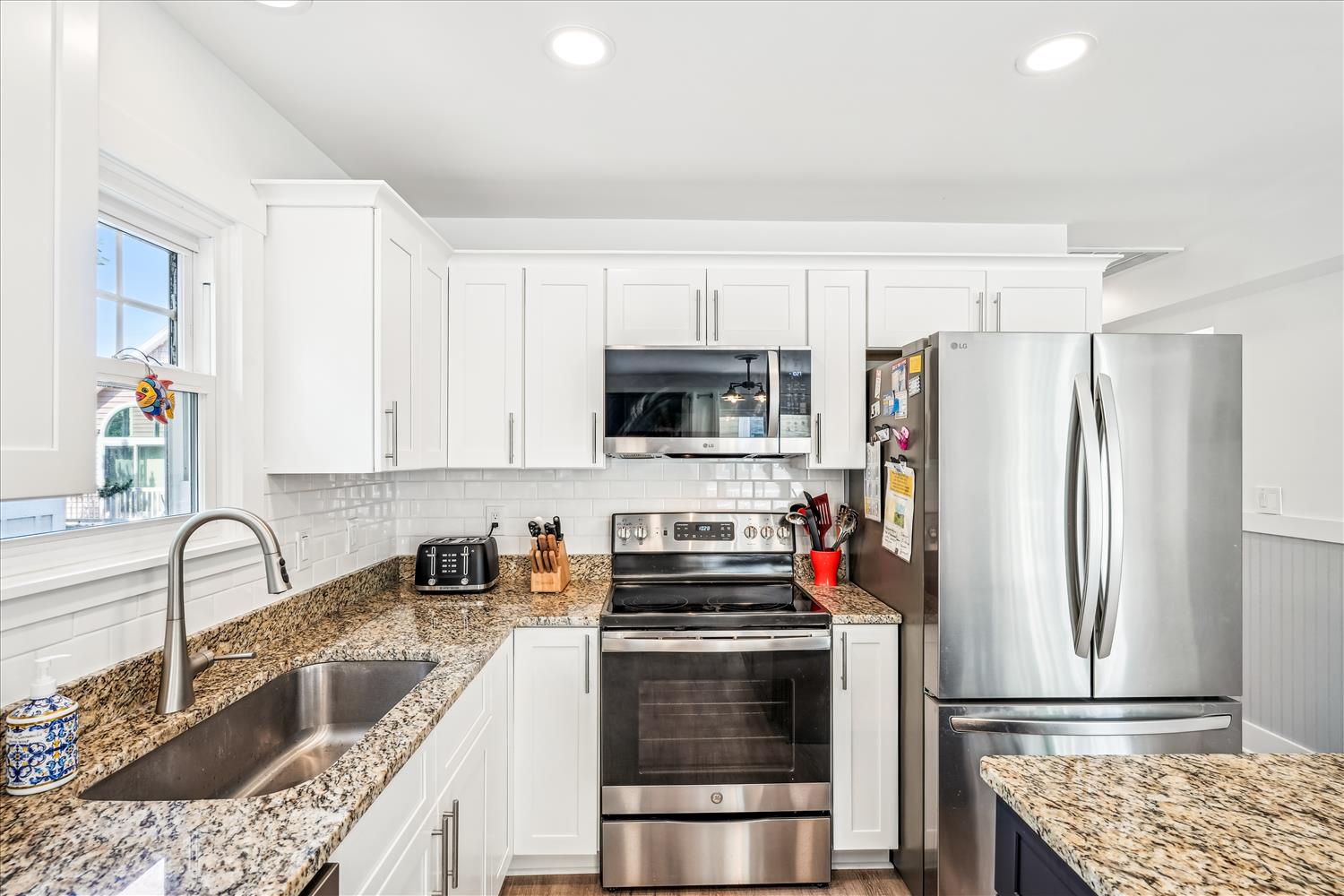 Your fully equipped kitchen features granite countertops, stainless steel appliances, and bright white cabinetry for memorable meal prep.