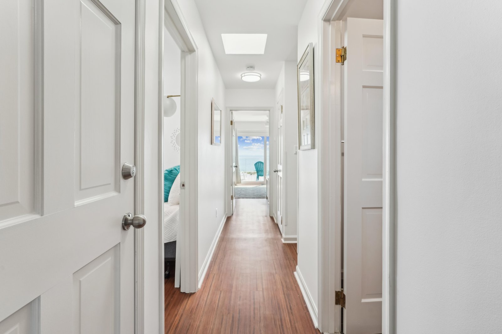 Step through this bright hallway and discover the calming ocean view awaiting you at the end—your serene coastal escape begins here.