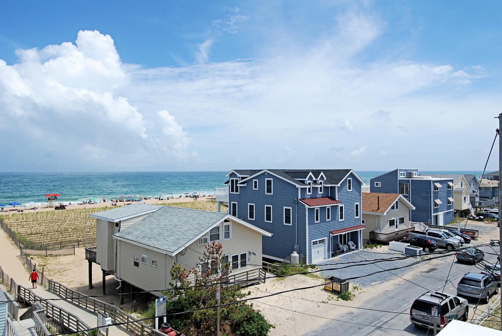 Coastal vacation homes situated steps from a pristine sandy beach, offering direct ocean access and stunning sea views in a vibrant beachfront neighborhood.