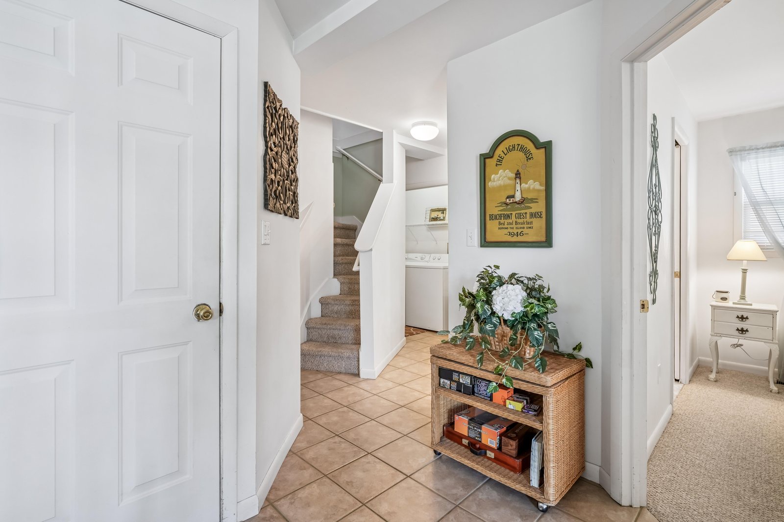 A bright, welcoming entryway with coastal charm greets you as you arrive, featuring warm tile floors and thoughtful touches that make you feel right at home.