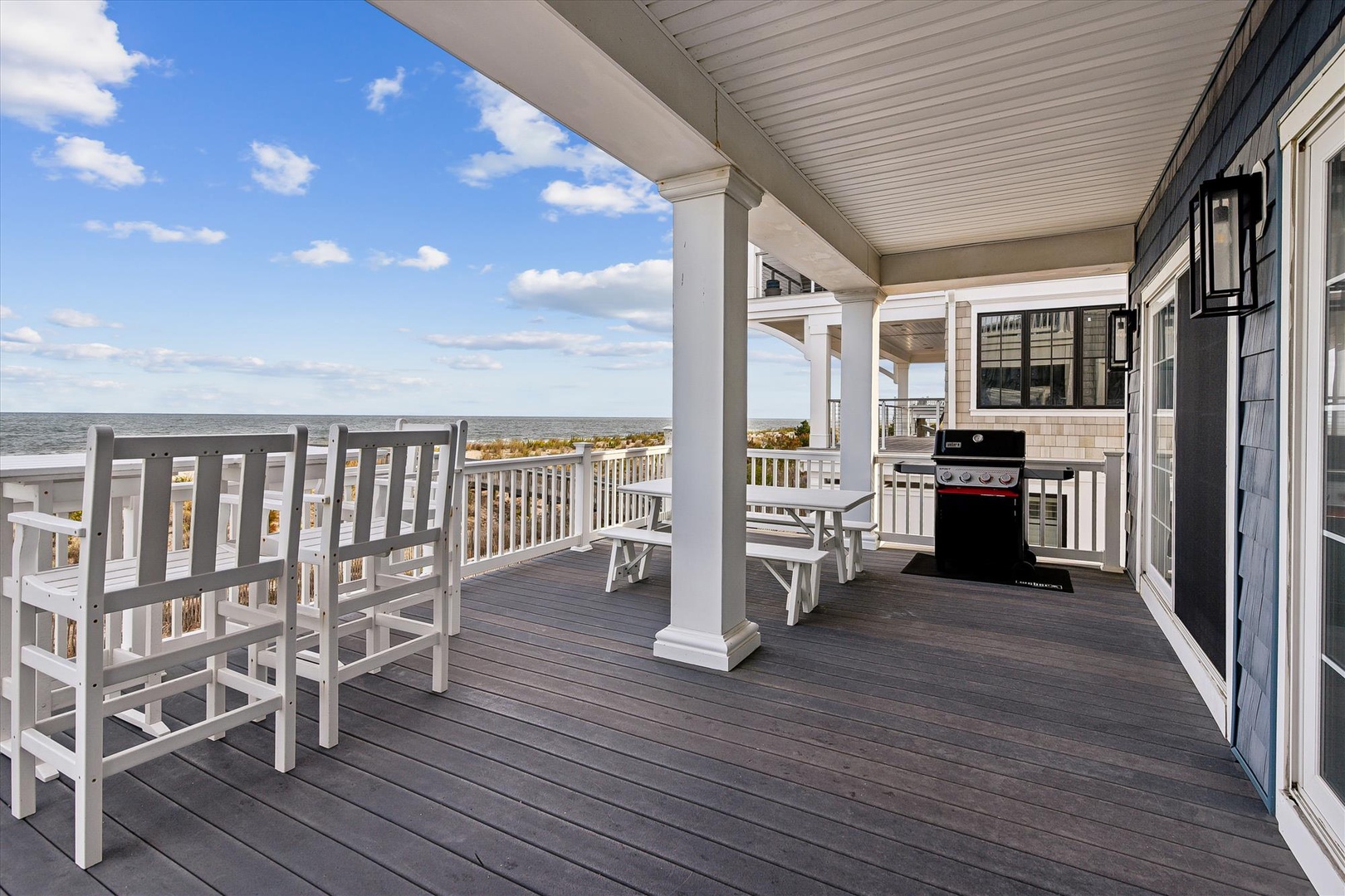 Your expansive balcony offers coastal breezes and sunset views, complete with a grill for alfresco dining and rocking chairs for relaxing with ocean sounds in the background.