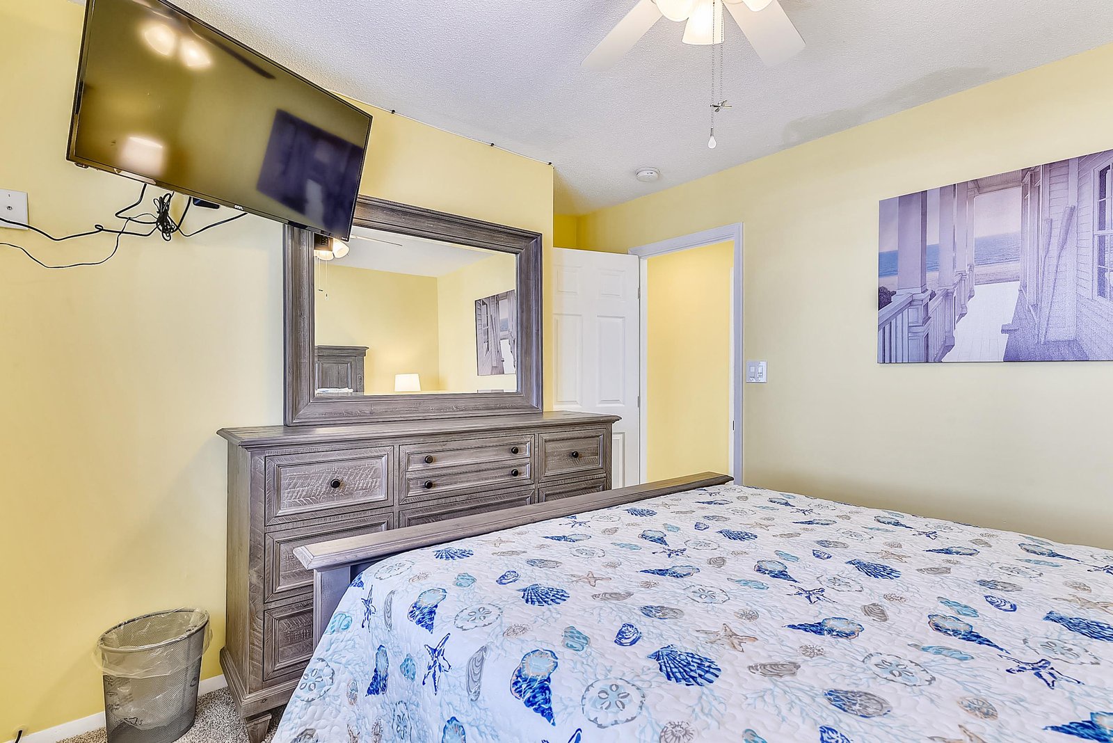 Relax in your cheerful bedroom with coastal-themed bedding, a well-appointed dresser, and all the comforts you need for a restful getaway.