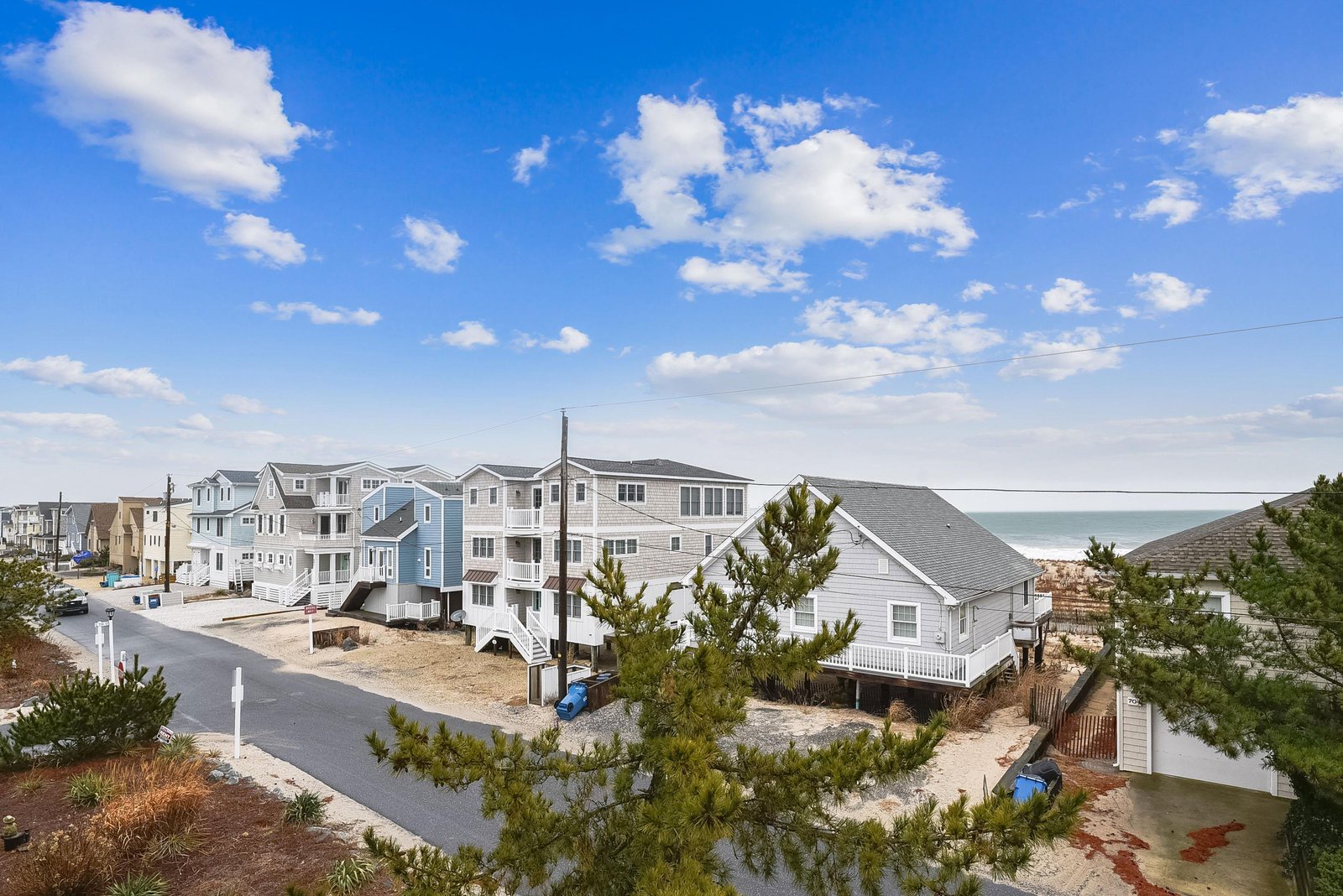 A coastal neighborhood featuring beach houses and multi-level vacation homes with ocean views just steps from the shore.
