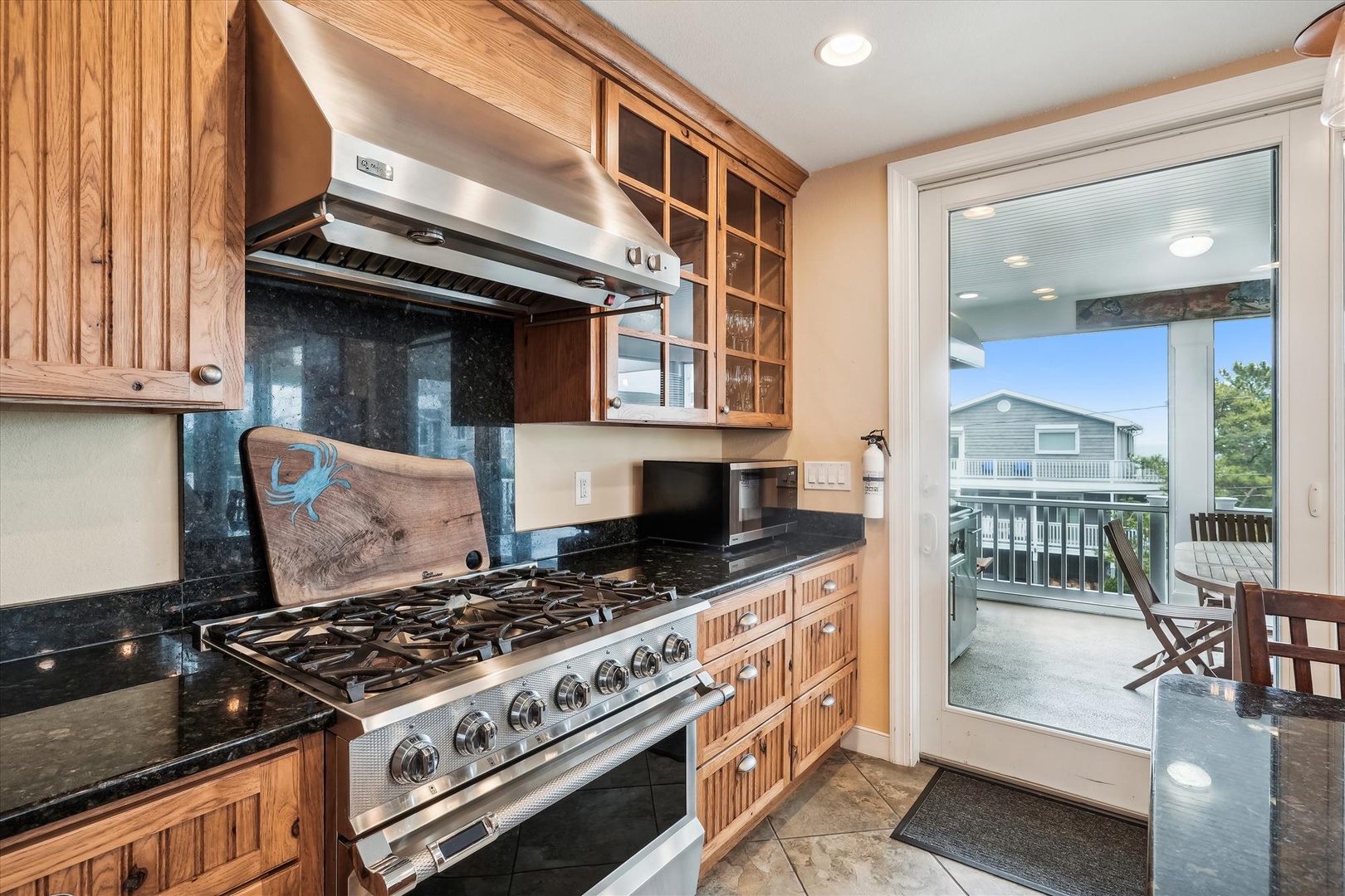 Cook your favorite meals on the professional-grade gas range, framed by warm wood cabinetry and gleaming granite counters, with the balcony just steps away.