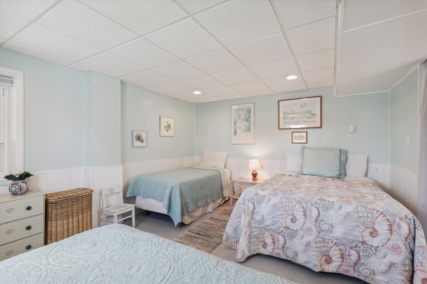 Your coastal-themed bedroom awaits with multiple comfortable beds, soft linens, and gentle beach-inspired decor that invites restful sleep and peaceful mornings by the shore.