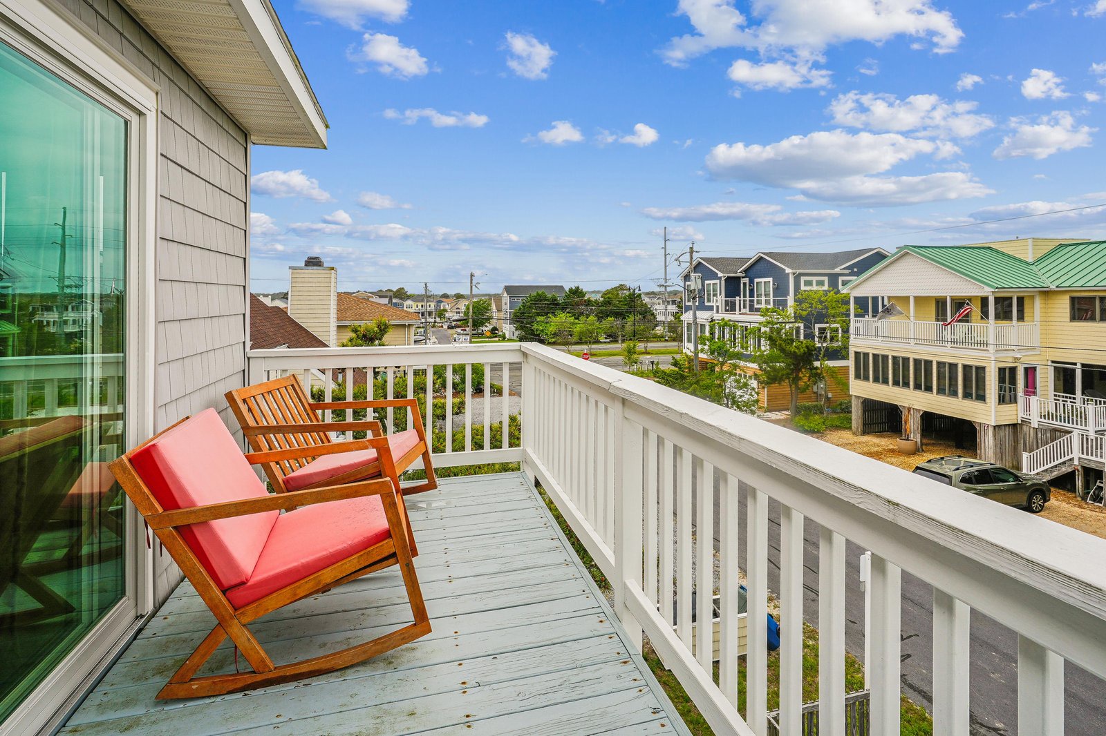 Relax on your private balcony with bright coral cushions and enjoy the peaceful neighborhood surroundings, perfect for morning coffee or evening downtime.