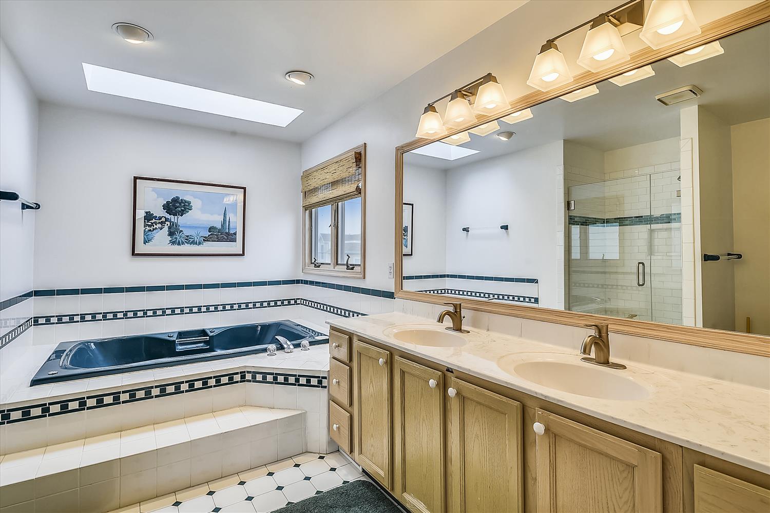Unwind in your luxurious master bathroom featuring a jetted soaking tub, dual vanities, and elegant tile work for ultimate relaxation.