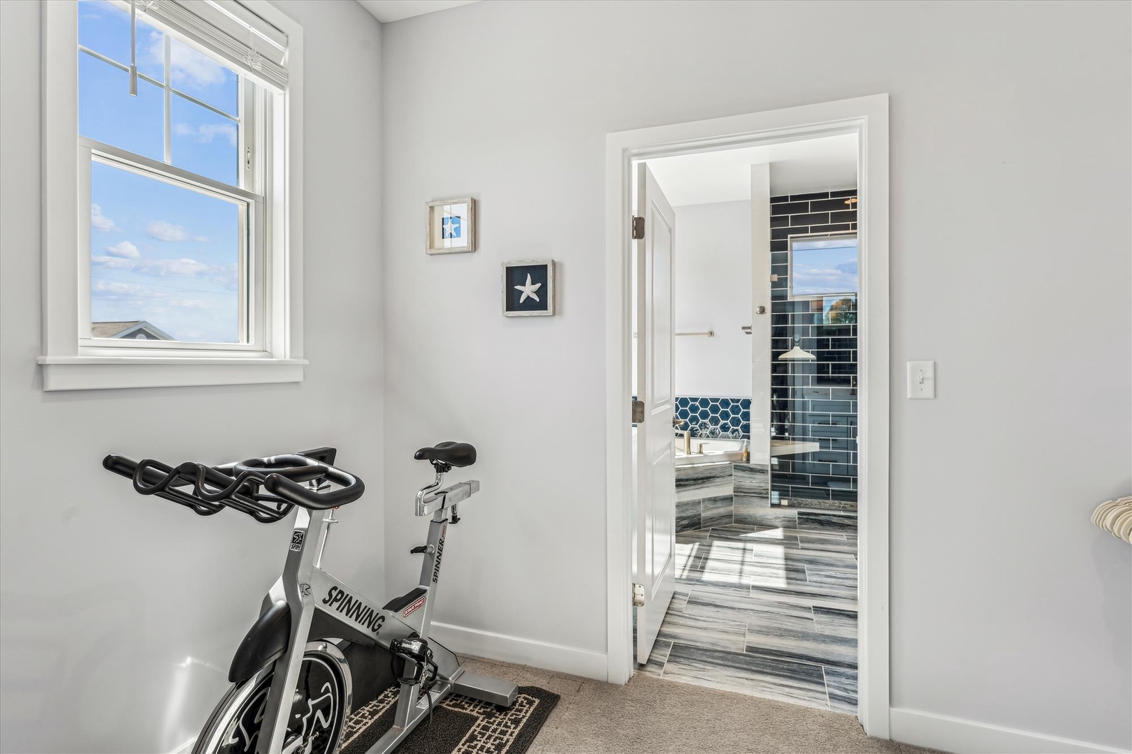 Stay active with your own in-home spin bike, just steps from the sleek, modern bathroom. Bright natural light fills the space, making every workout feel energizing.
