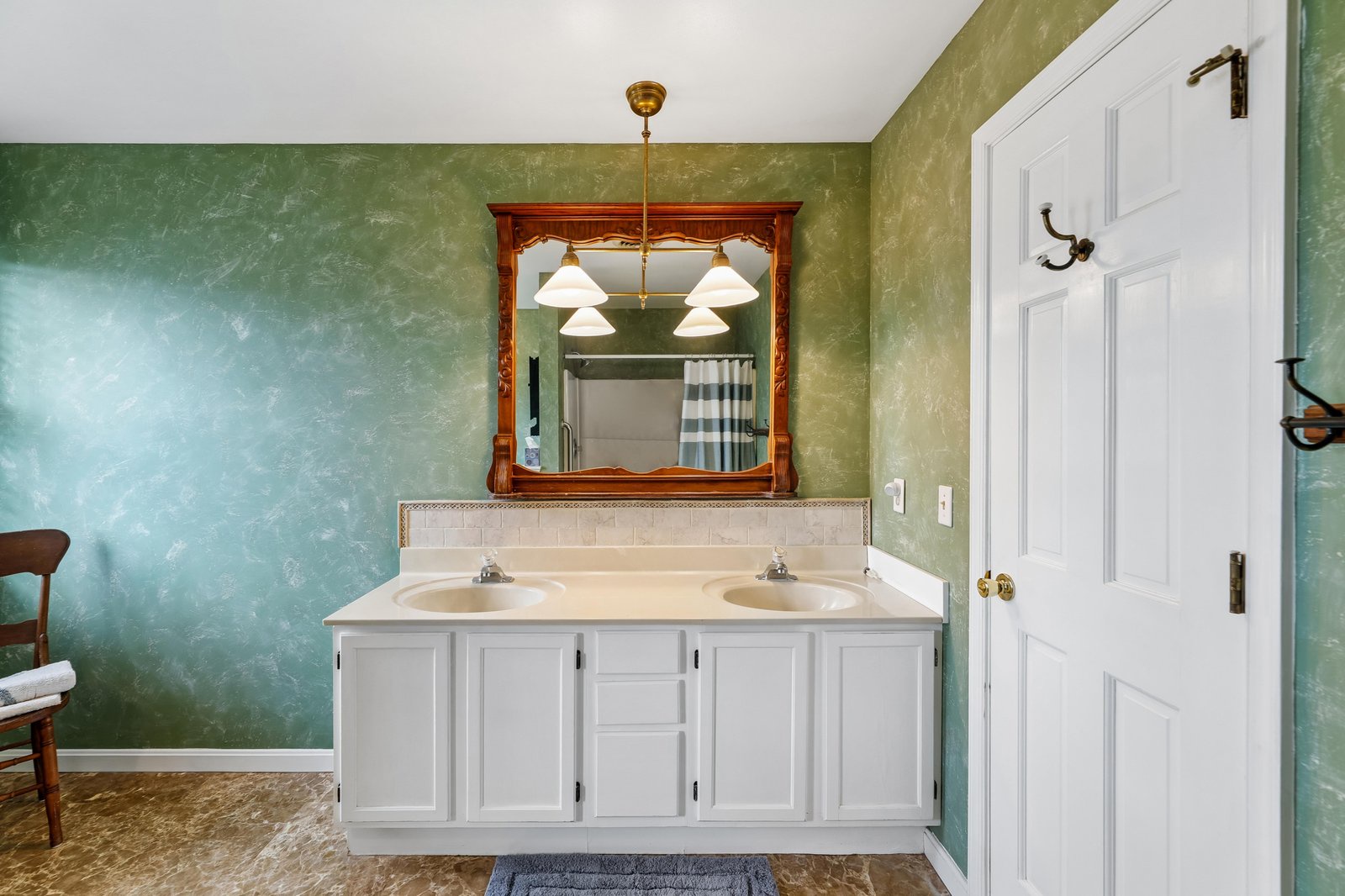 Freshen up at your spacious double-sink vanity, set against tranquil ombre walls that shift from sage to seafoam. The generous counter gives you plenty of room to spread out and get ready for your day.